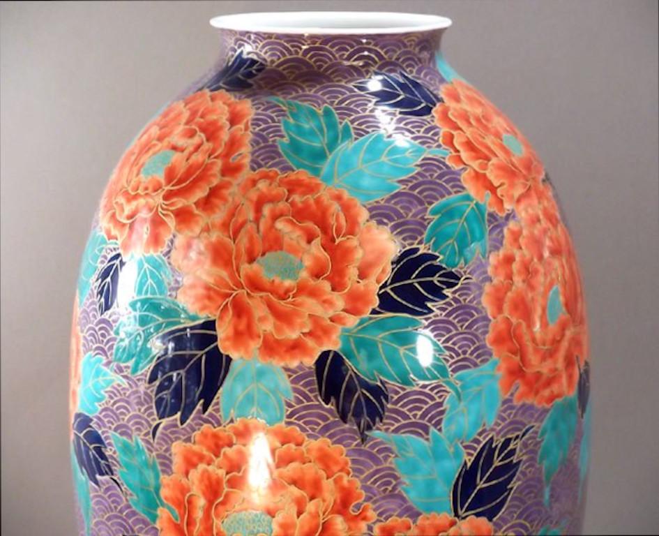 Exquis vase contemporain en porcelaine japonaise, doré et peint à la main en rouge, violet et vert sur un corps de forme étonnante, un chef-d'œuvre signé par un maître artiste de la porcelaine de la région d'Arita-Imari au Japon. En 2016, le British