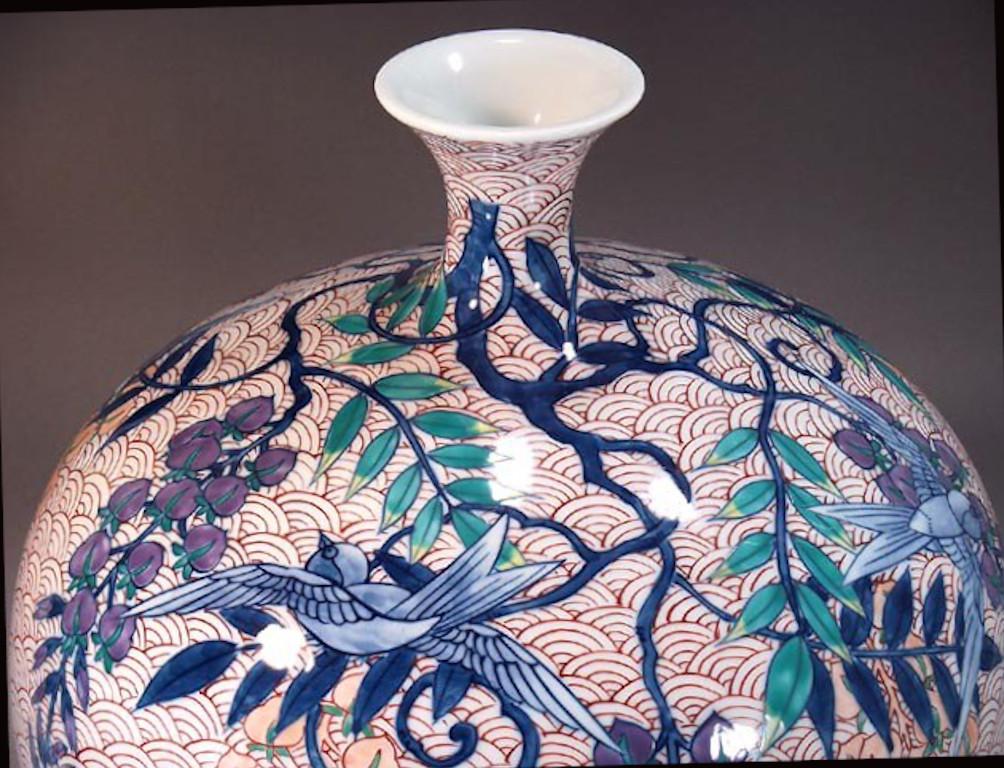 Vase en porcelaine décoratif contemporain japonais, peint à la main en rouge, violet et bleu sur un corps en porcelaine de belle forme, une pièce signée par un artiste en porcelaine très réputé de la région d'Imari-Arita au Japon. L'artiste a reçu