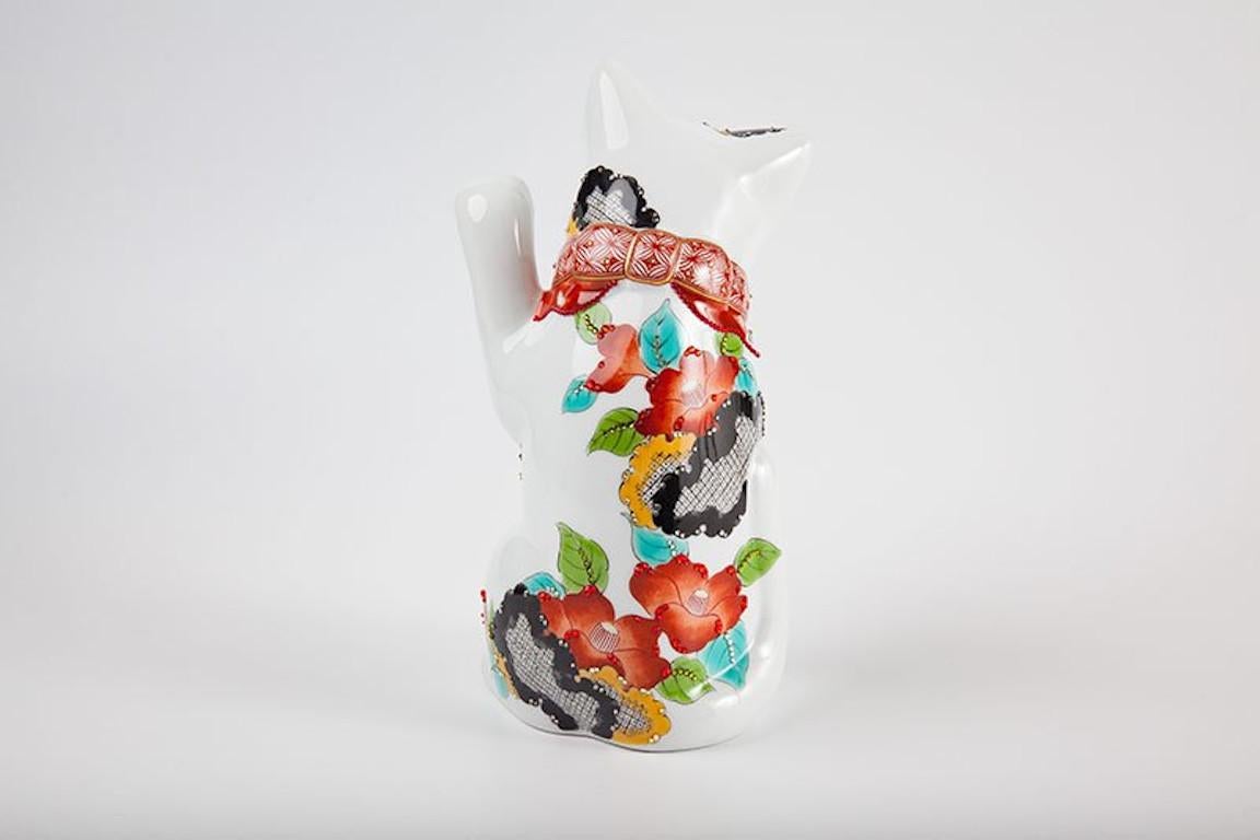 Exquisite contemporary Japanese lucky cat (maneki neko,) raising his left paw. Swarovsky crystals generously adorn this stunning lucky cat with intricate pattens in red, green, yellow, blue and gold. Elegant bold camelias decorate the back and sids