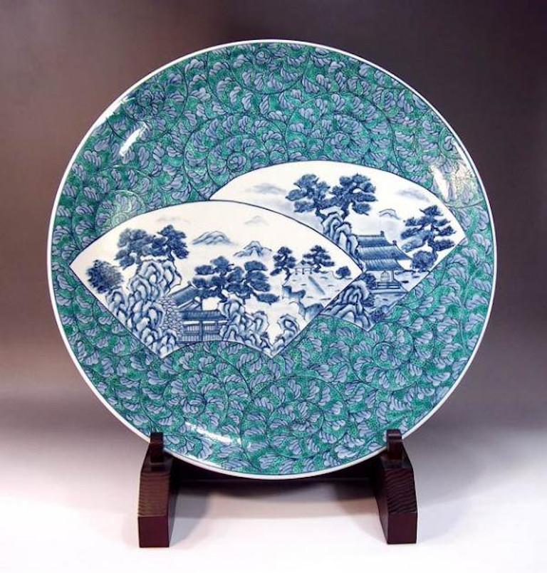 Exctraordinary contemporary Japanese porcelain decorative charger, extremely intricately hand painted in an auspicious karakusa pattern in underglaze blue and white with some green , depicting scenes from Japan's countryside showcased on fan shaped