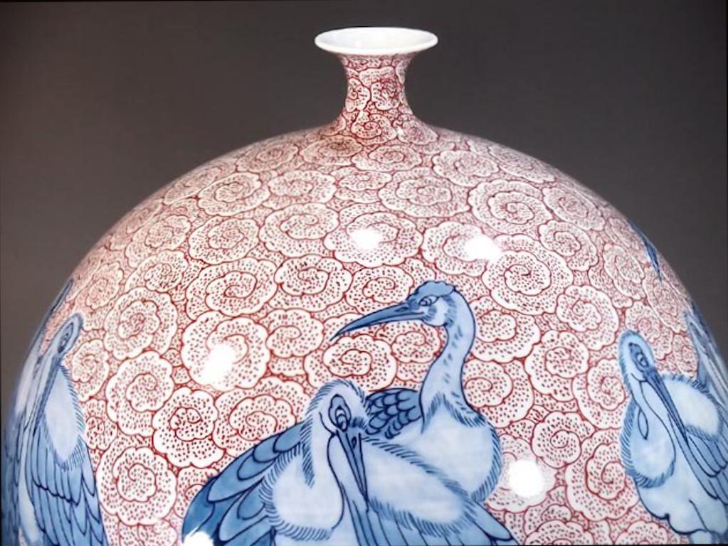 Vase unique en porcelaine décorative japonaise contemporaine, peint à la main en bleu sous glaçure et en rouge sur un corps en porcelaine ovoïde de belle forme en blanc pur, une pièce signée par un maître porcelainier primé très acclamé de la région