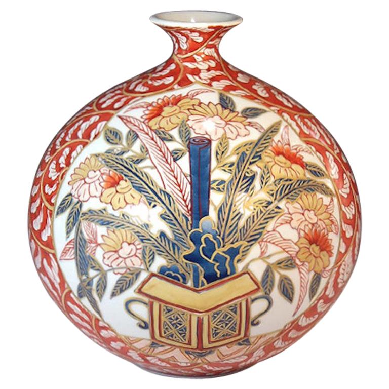 Elegante jarrón decorativo contemporáneo de porcelana japonesa, bellamente pintado a mano en rojo, blanco y azul sobre un cuerpo de formas llamativas, una obra firmada por el aclamado maestro japonés de la porcelana de tradición Imari-Arita de