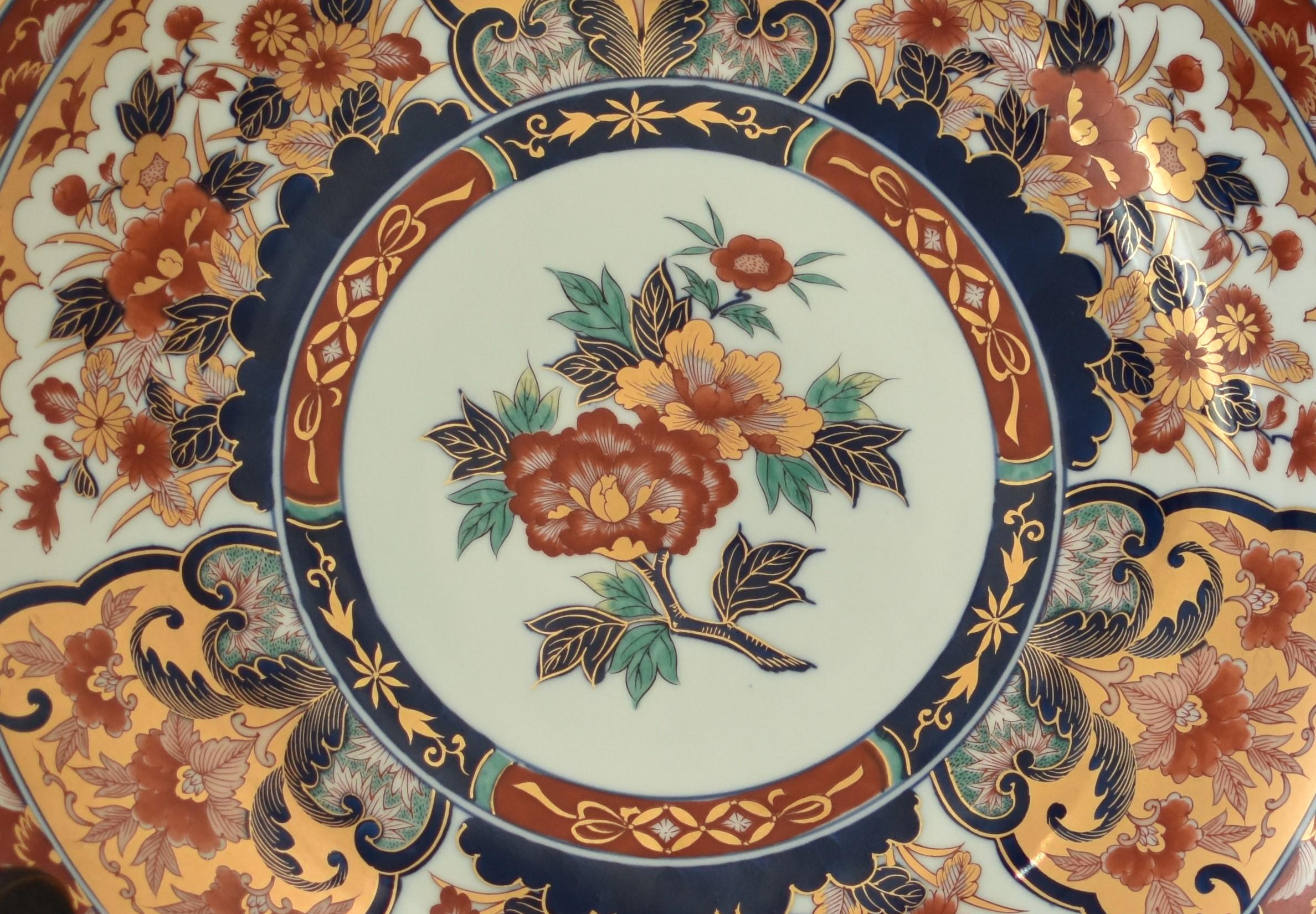 Japanese contemporary gilded porcelain Ko-Imari (old Imari) charger in blue, red, green and gold. The medallion in the center is decorated with an attractive peony in iron-red and foliage in various shades of blue and green on a pure white