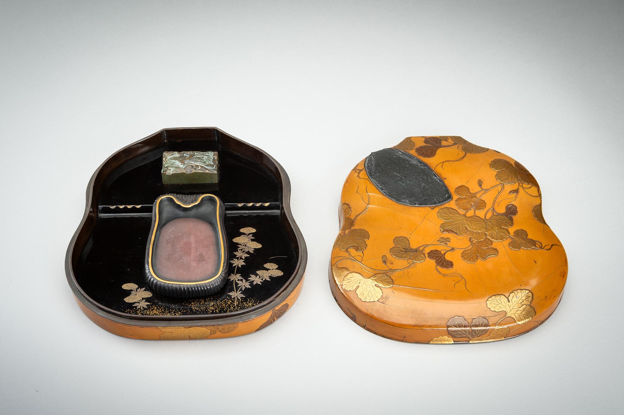 An uniquely double-gourd-shaped lacquer suzuri’bako (writing box) with a design of gourd leaves, by Hara Yôyûsai (1769-1845).
Covered with amber coloured lacquer and decorated in gold, orange and brown takamaki-e 高蒔絵 with gourd leaves and a waning