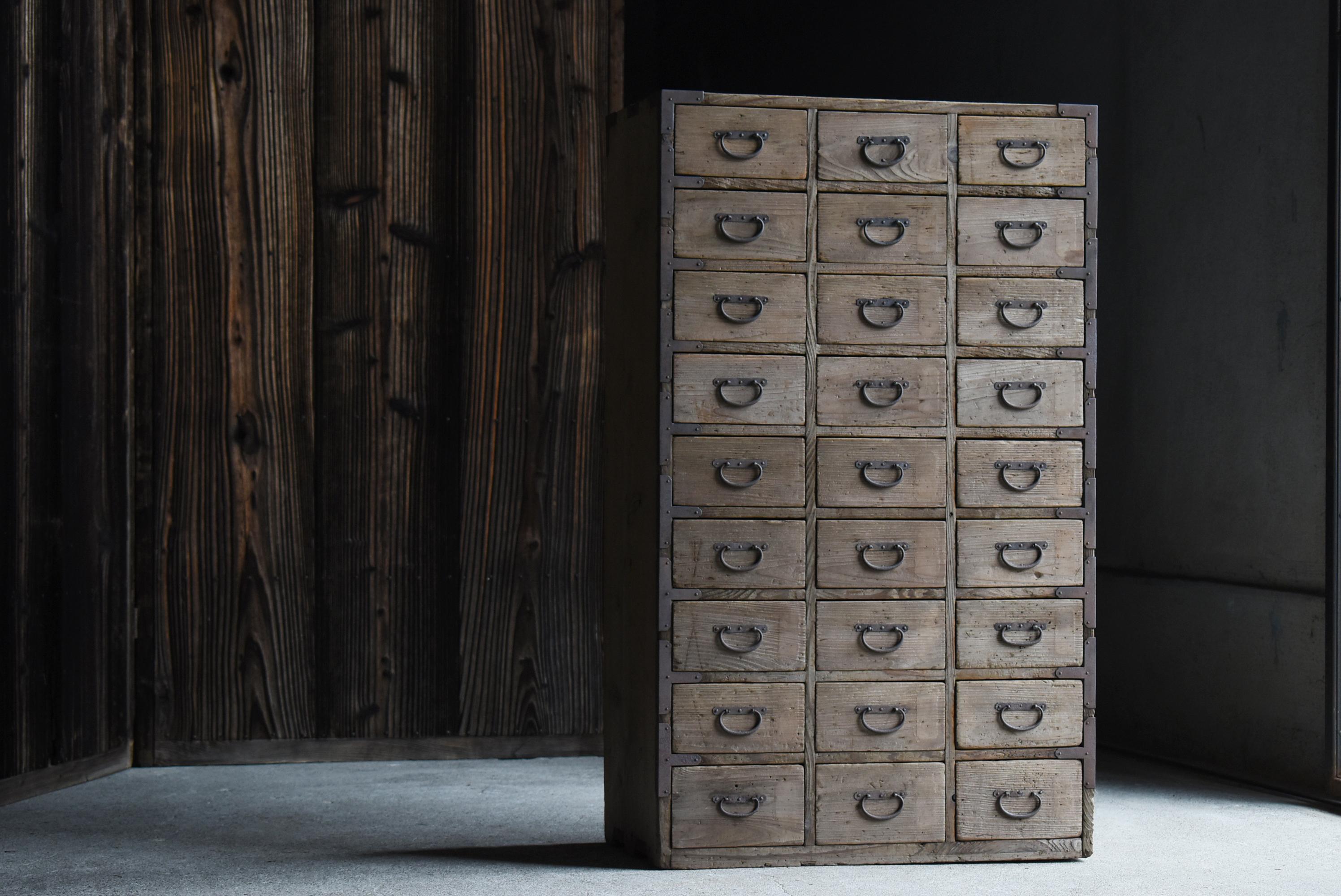 This is a drawer storage made in Japan.
It was made in the Taisho period (1900s-1920s) and is made of quaint cedar wood. The handles are made of iron, preserving the flavor of the period.

The 27 small drawers neatly lined up in an orderly fashion