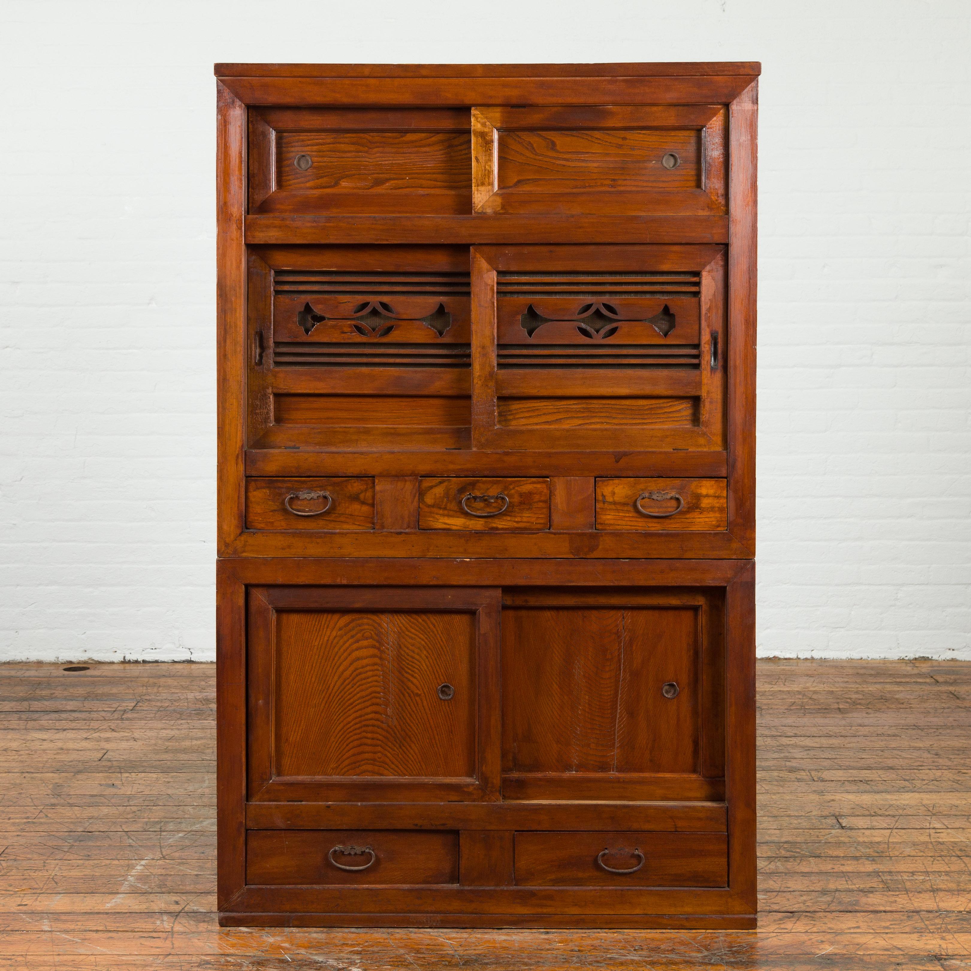 A Japanese Taisho period kitchen tansu cabinet from the early 20th century, with sliding doors. Created in Japan during the early years of the 20th century, this Japanese tansu cabinet features a linear silhouette perfectly complimented by a warm