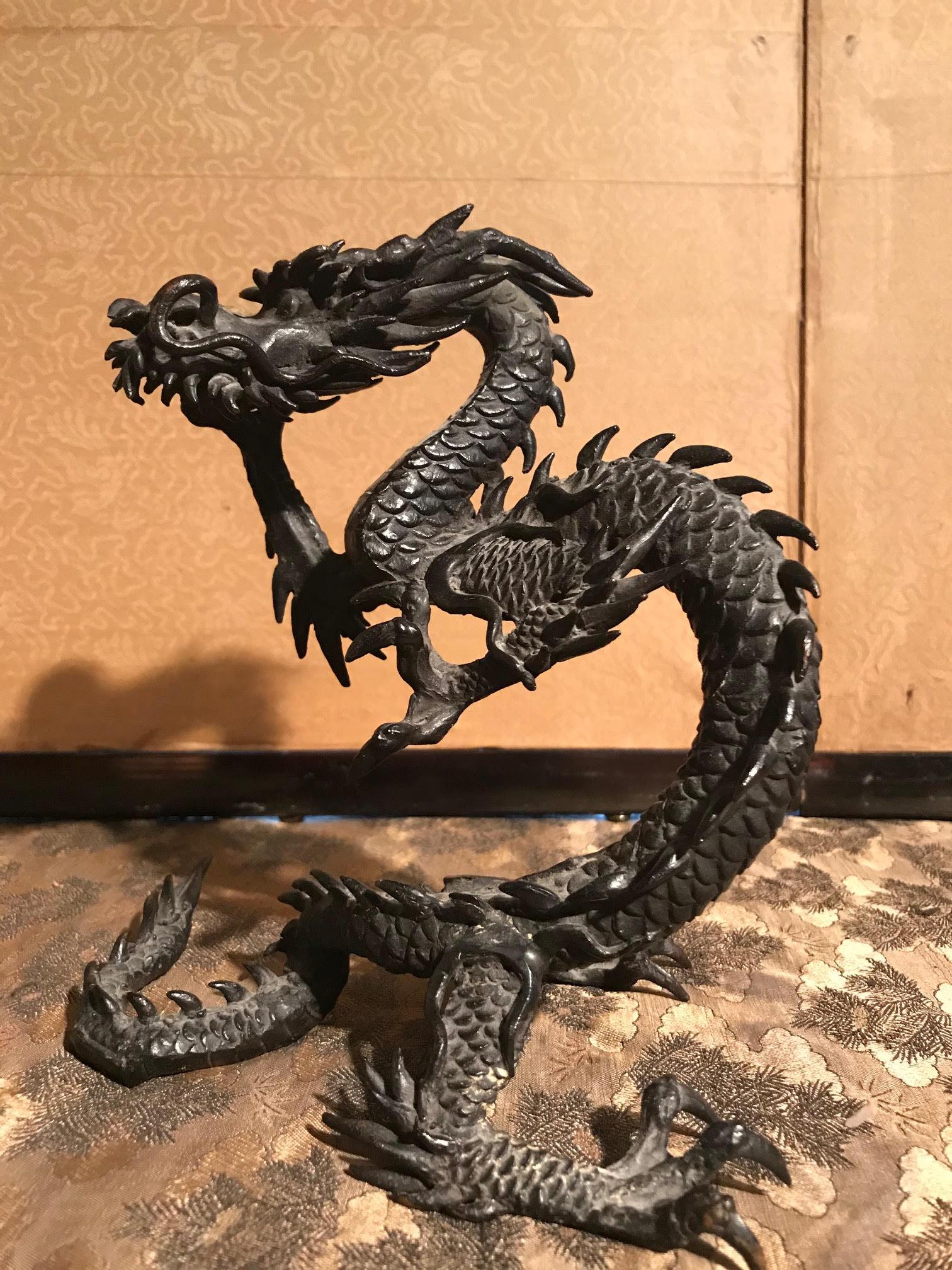Japanese Meiji period bronze dragon sculpture holding up a gilt bronze ball. The piece was likely made in circa 1890 and has a rich dark bronze patina. It has a makers mark on the bottom. In great antique condition with age-appropriate wear and use.