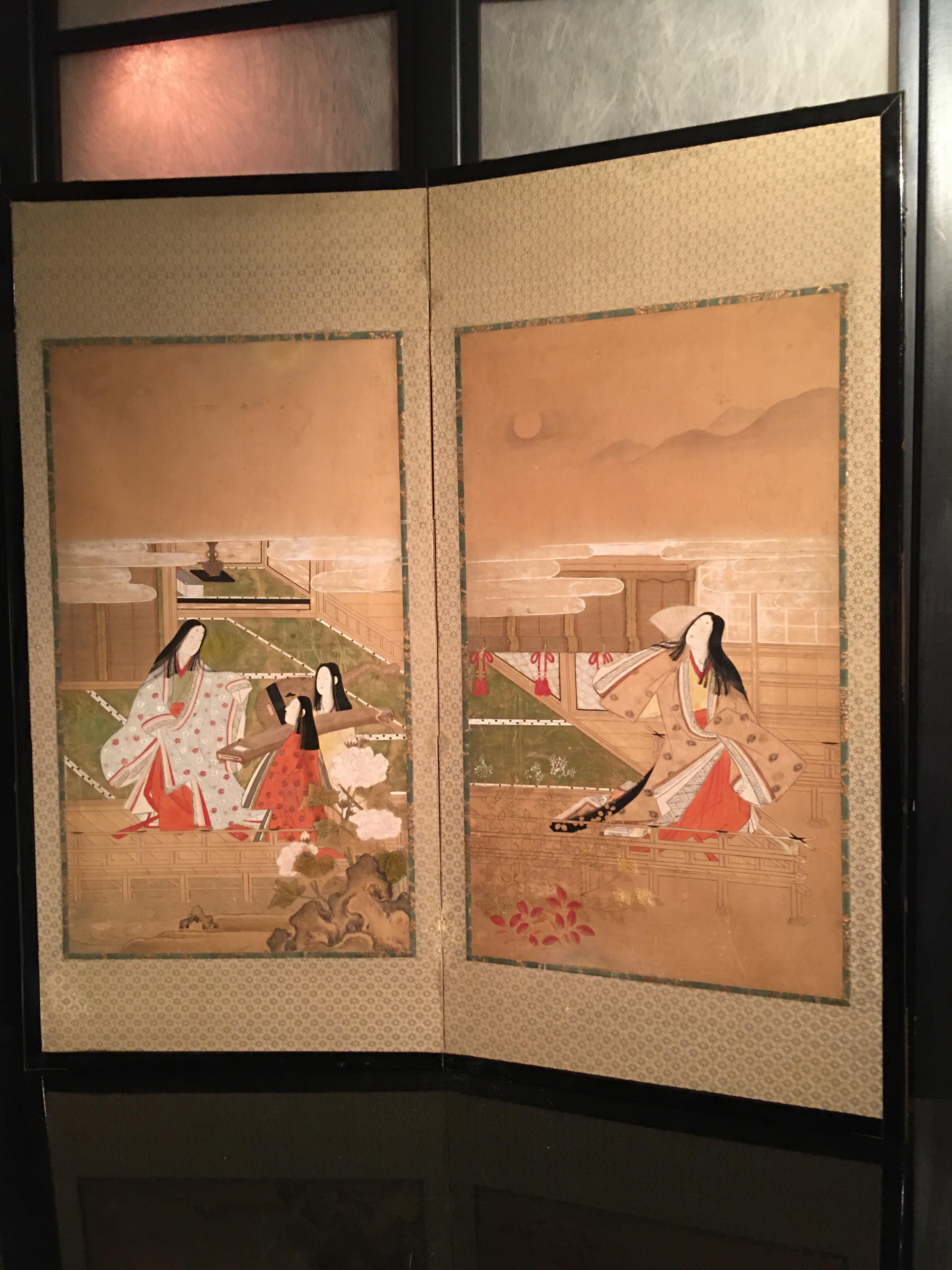 Japanese Edo period two-panel screen with a pair of finely painted imperial court scenes representing court ladies as poets and musicians. The paintings are 17th century Edo period, possibly mounted at a later moment on the black lacquered