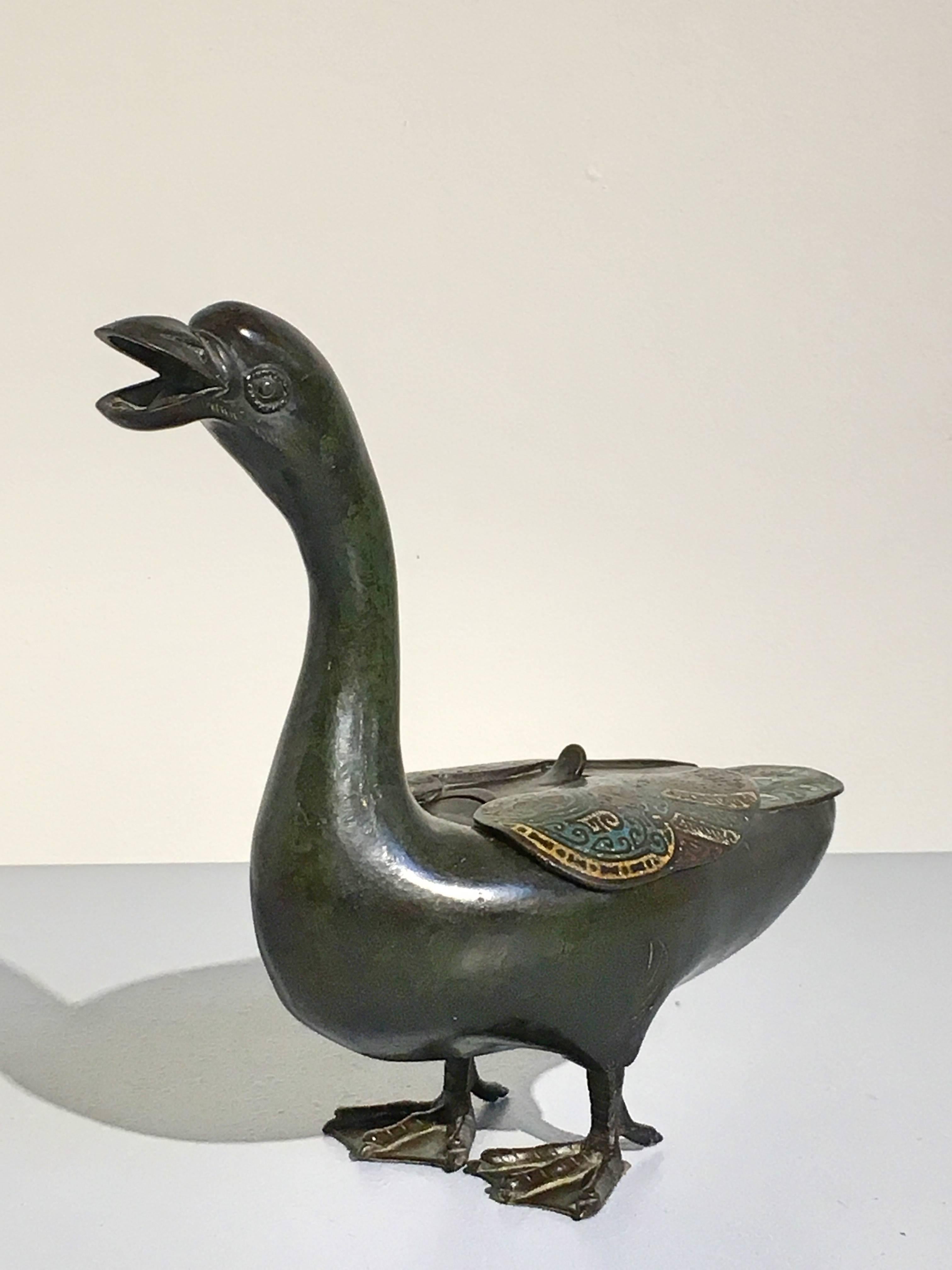 Charmant brûleur d'encens japonais en bronze en forme d'oie ou de canard, période Edo, milieu du XIXe siècle. La volaille bien moulée se tient debout sur deux pieds palmés, le long cou tendu, la tête levée et le bec large ouvert. Les ailes repliées