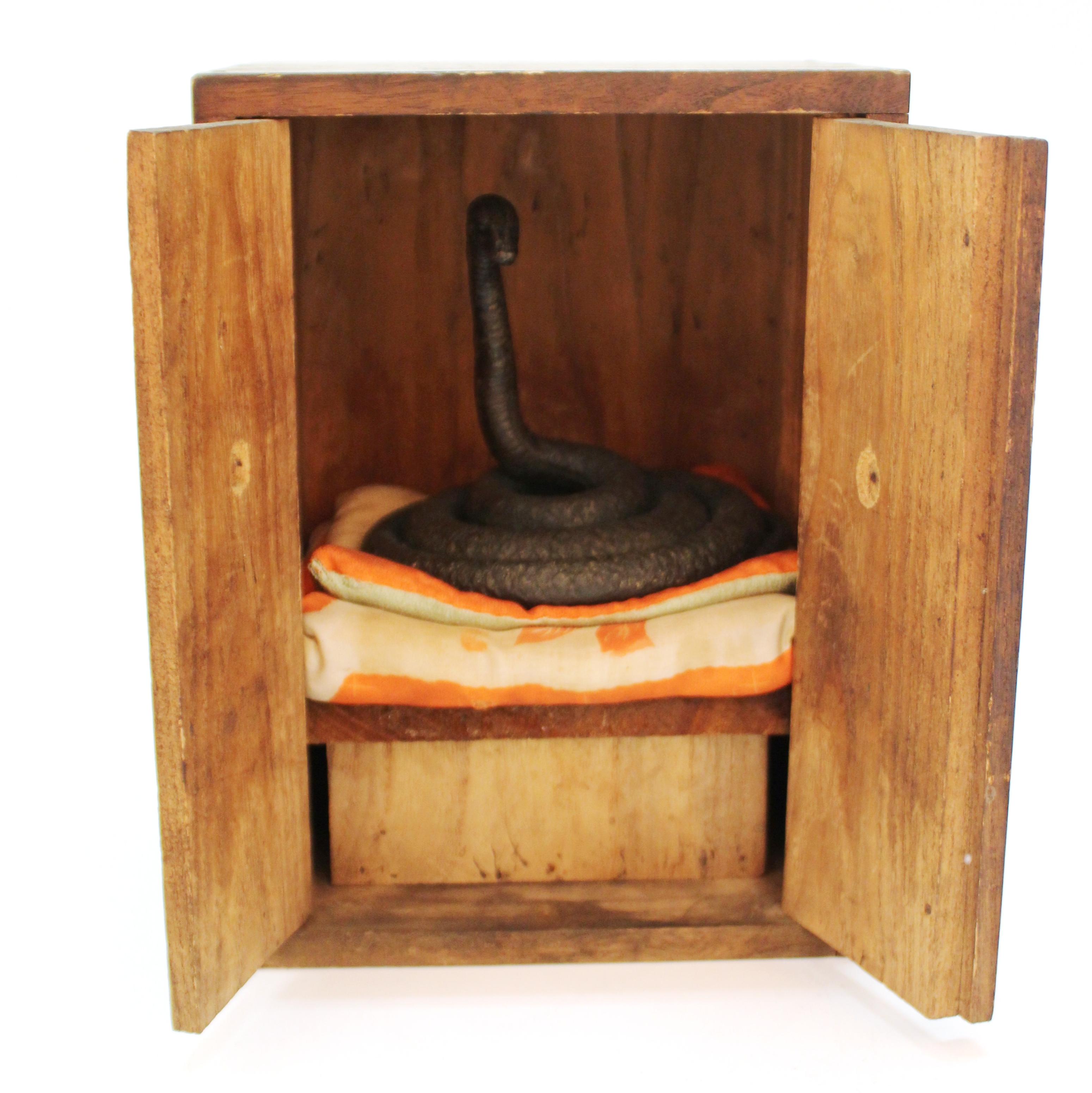 Japanese Edo period bronze snake with wood shrine. The snake sits atop a set of pillows on a wooden bench contained within a wooden shrine box with hinged wooden doors. The snake was likely made between 1800-1850 and is an extremely rare example of