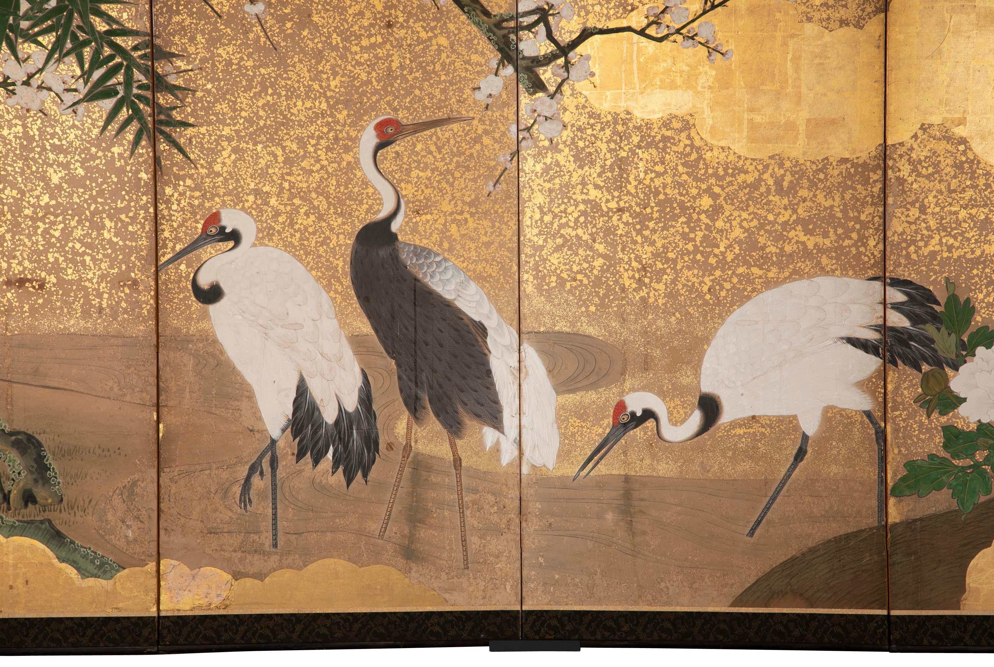 A Edo period screen depicting Cranes by a river with gilt cloud and peony decoration. 19th century Japanese.