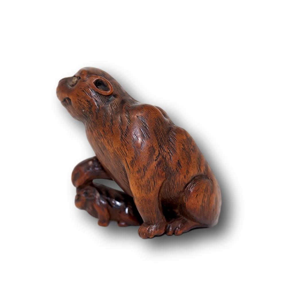 Japanese boxwood netsuke depicting a Tiger & cub. The netsuke featuring a large tiger holding its paw aloft with its cub underneath. Each with translucent horn eyes elevating the netsuke, signed to the base Masayoshi. The carving with excellent wear
