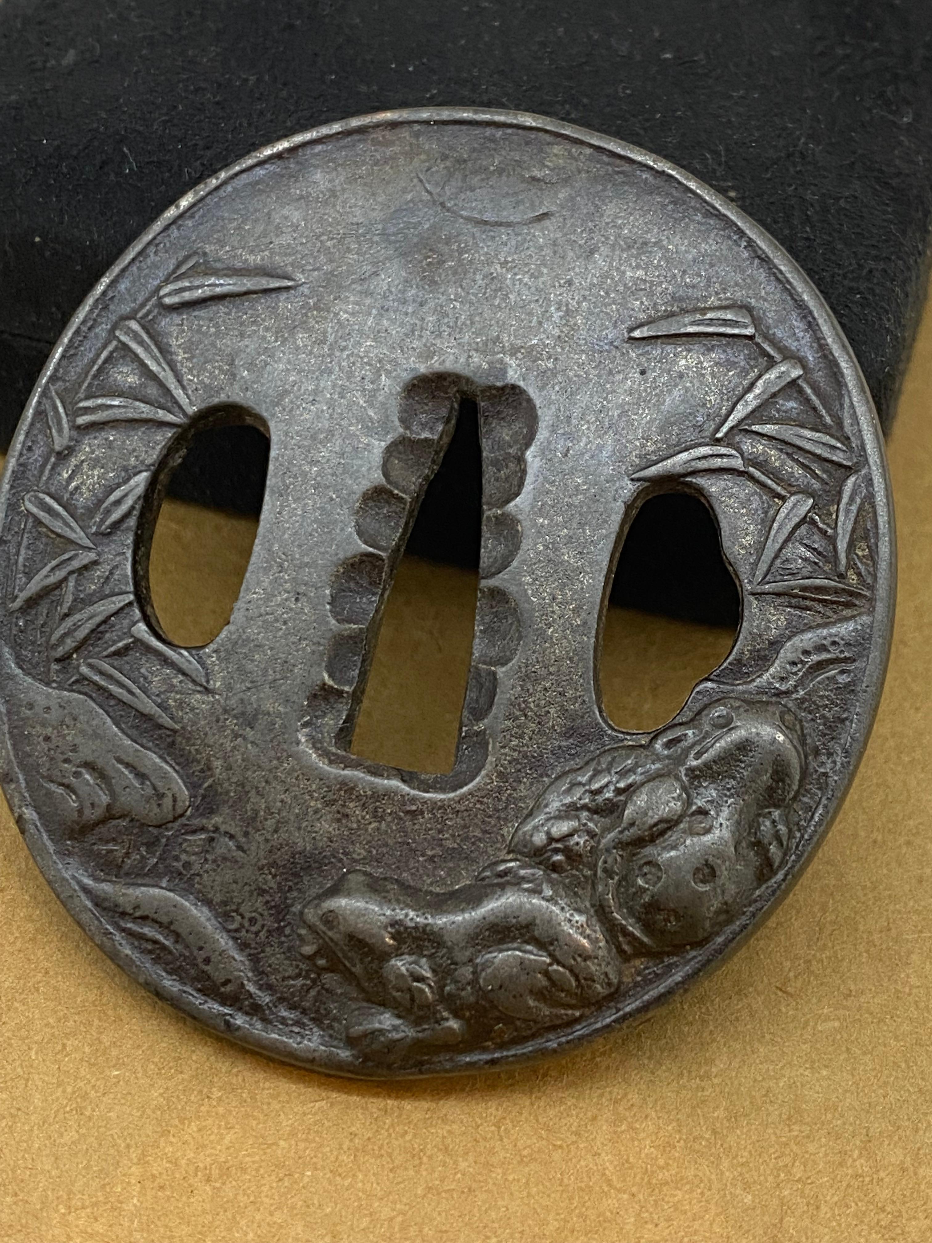 Cet article intrigant est une Tsuba, 
Garde d'un sabre japonais qui fait partie de la monture de l'épée. 
Il est placé entre la lame et la poignée pour protéger les mains de l'utilisateur.

Datant du début de la période Edo - XVIIe siècle 

Fabriqué