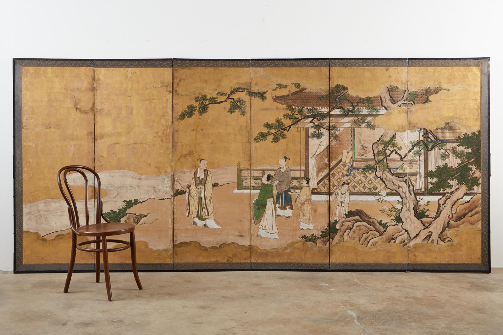 Early 18th century Japanese Tokugawa Edo period six-panel kano screen depicting the Emperor in conversation on a garden terrace. Crafted from ink and natural color pigments on gold leaf squares set in a lacquered frame. The genre is based on the