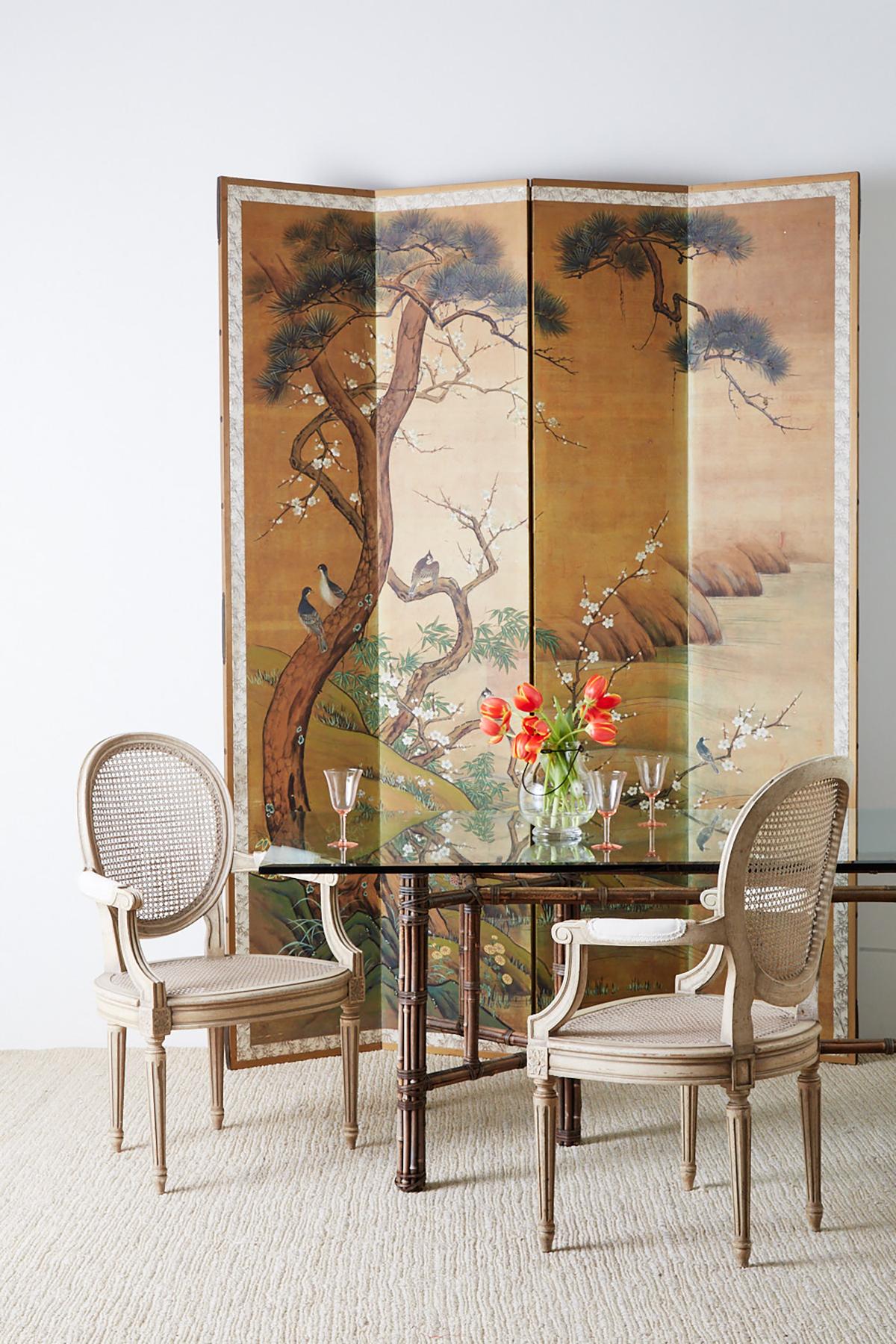 Monumental Japanese four-panel folding screen made in the Edo period style. Depicts an idyllic spring landscape scene with blooming Sakura Cherry blossoms and pine trees among flowers. There are several different birds in each tree. Signed and
