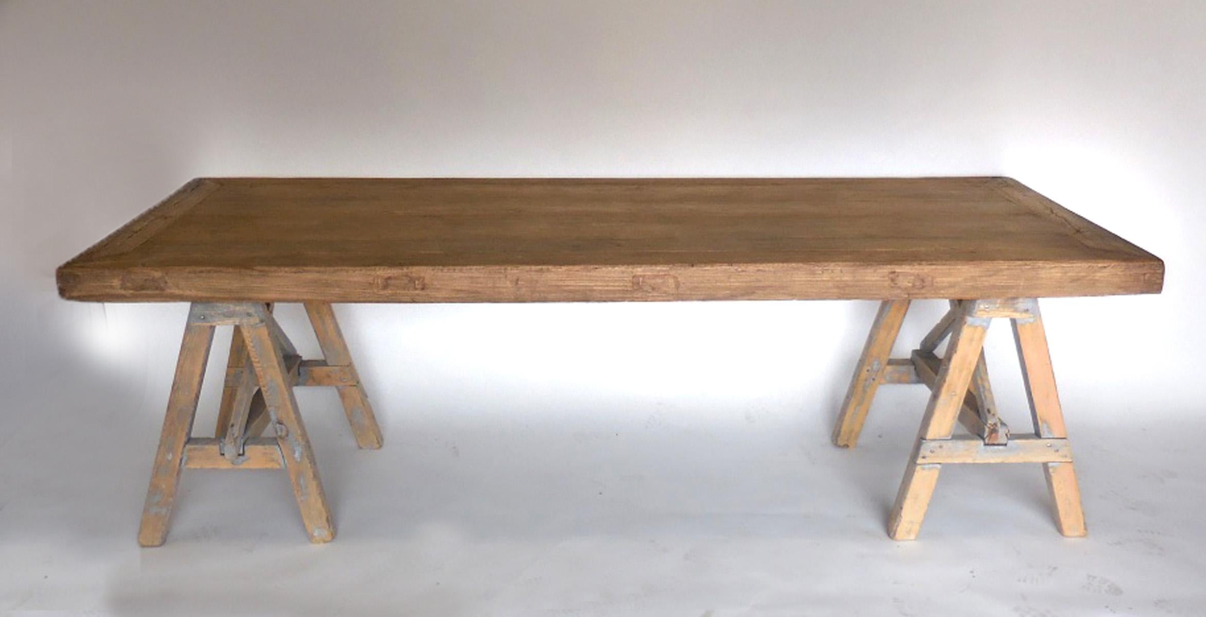 Here is a marriage of an old Japanese table top and old French pine saw horse bases. The top is beautifully constructed with mortise and tenon and the edges of the table are 3 inches thick. The graining is rich and smooth to the touch. The bases