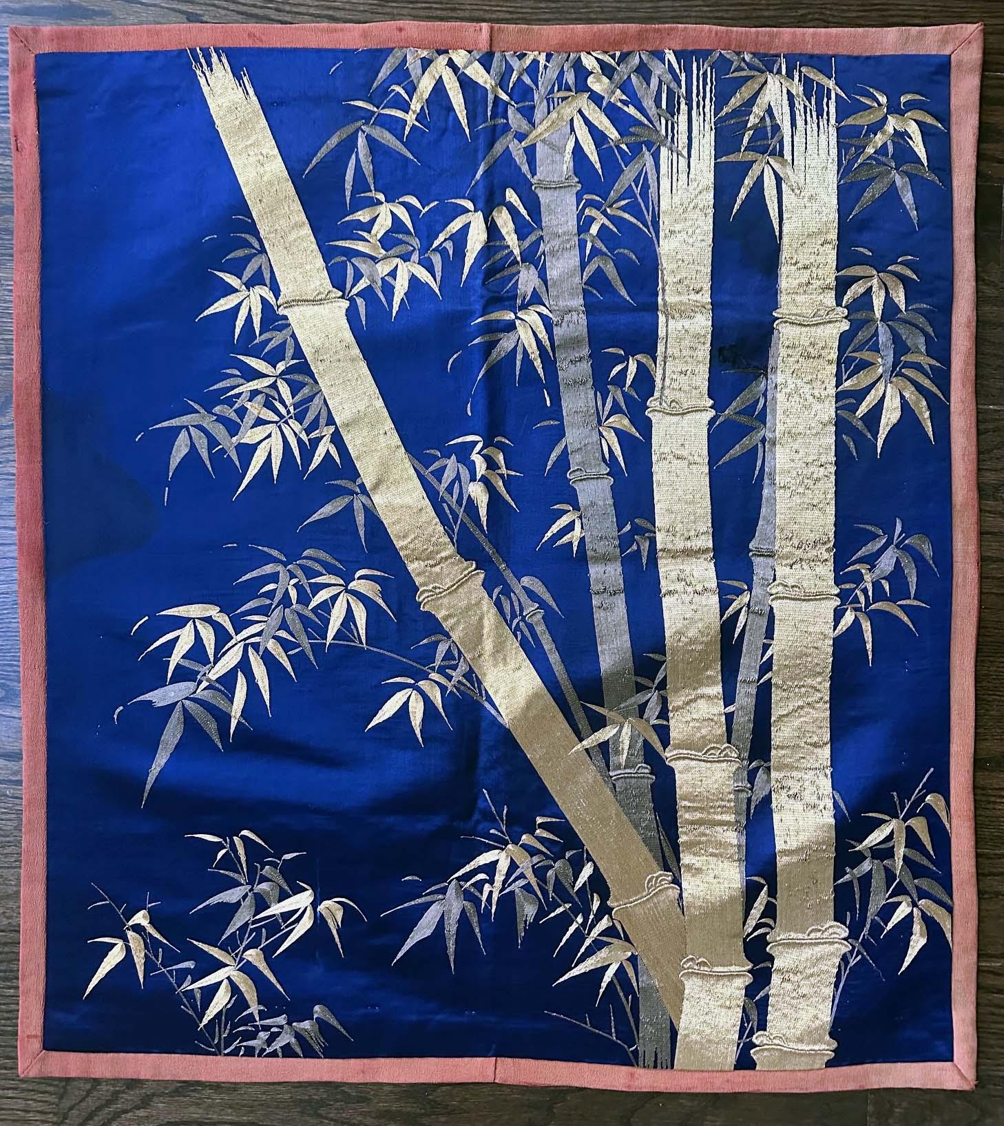 A Japanese silk embroidery Fukusa panel circa 1890-1910s toward the end of Meiji Period. On the deep blue satin background, the artist showcases a clump of bamboos in a realistic style. Two shades of gold threads were used in the composition in