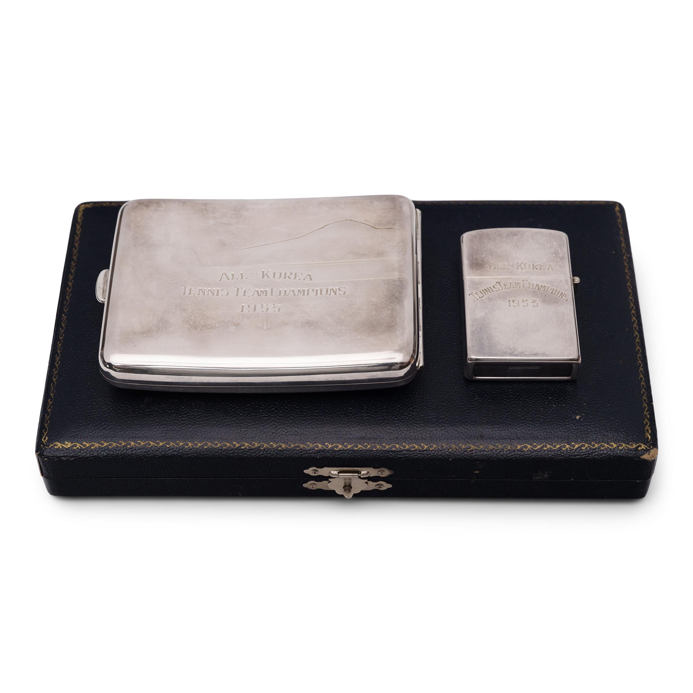 This matching set of engraved silver cigarette accessories exemplifies Japanese refinement in all crafts. The set includes a rectangular cigarette case and a lighter, now emptied of the interior mechanism. Both are finely engraved with mountainside