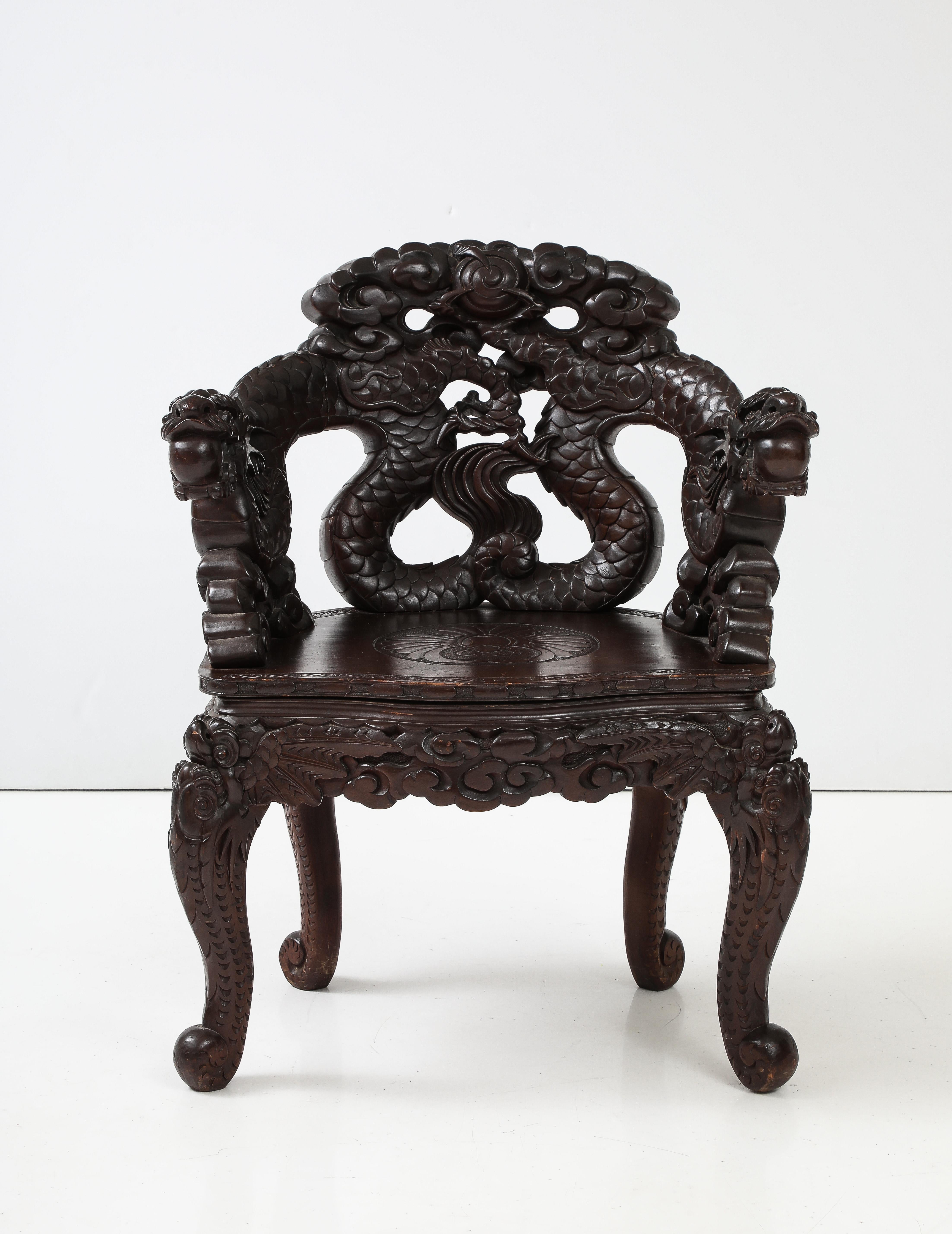 Eye catching highly carved sculptural dragon armchair. Japanese dragon motif carried throughout arms and chair with fantastic detailed hand carvings. Victorian era cabriole legs finish the design. 