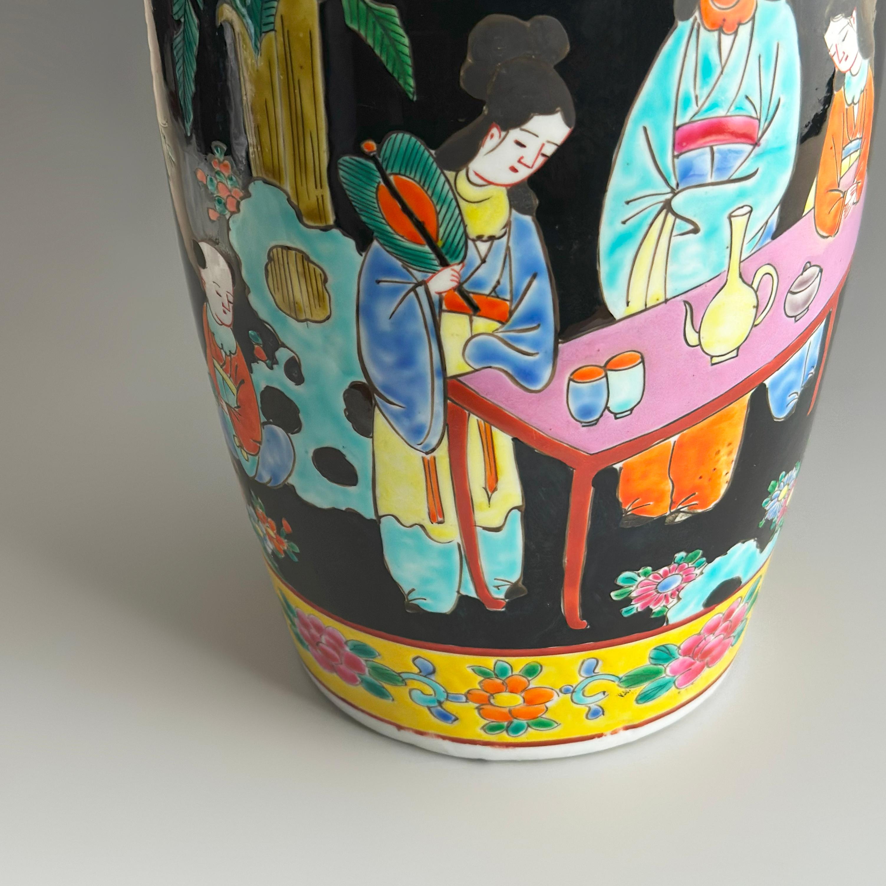 A large and vibrant Japanese porcelain vase in the classic rouleau form, crafted in the early 1950s by the Yamatoku kiln in the renowned Arita porcelain region. This striking piece is decorated in the Famille Noire palette, a richly coloured enamel