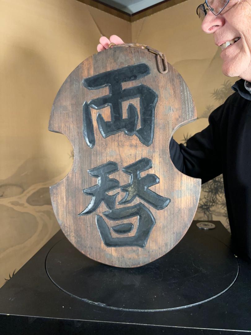 Japan, a beautifully handmade and hand carved black lacquer colored antique shop sign -kanban- for a Japanese currency exchange shop. The kanji translates to 