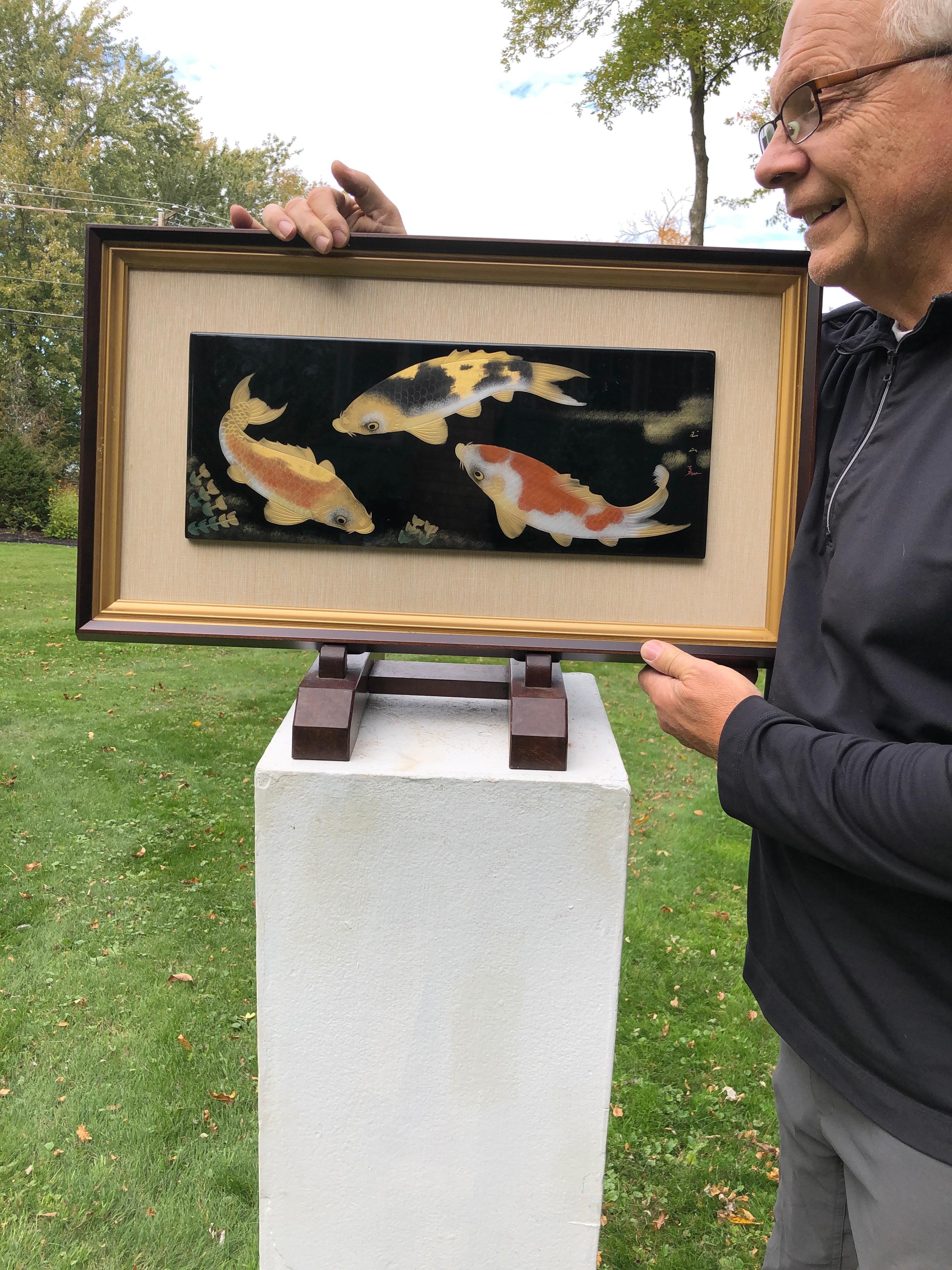 From our recent Japanese Acquisitions travels.

Stunning Artisan Creation.

A superb Makie Lacquer framed panel of three koi - beautifully rendered by a master Japanese artisan. Three rich black and gold Koi are hand drawn gracefully plying