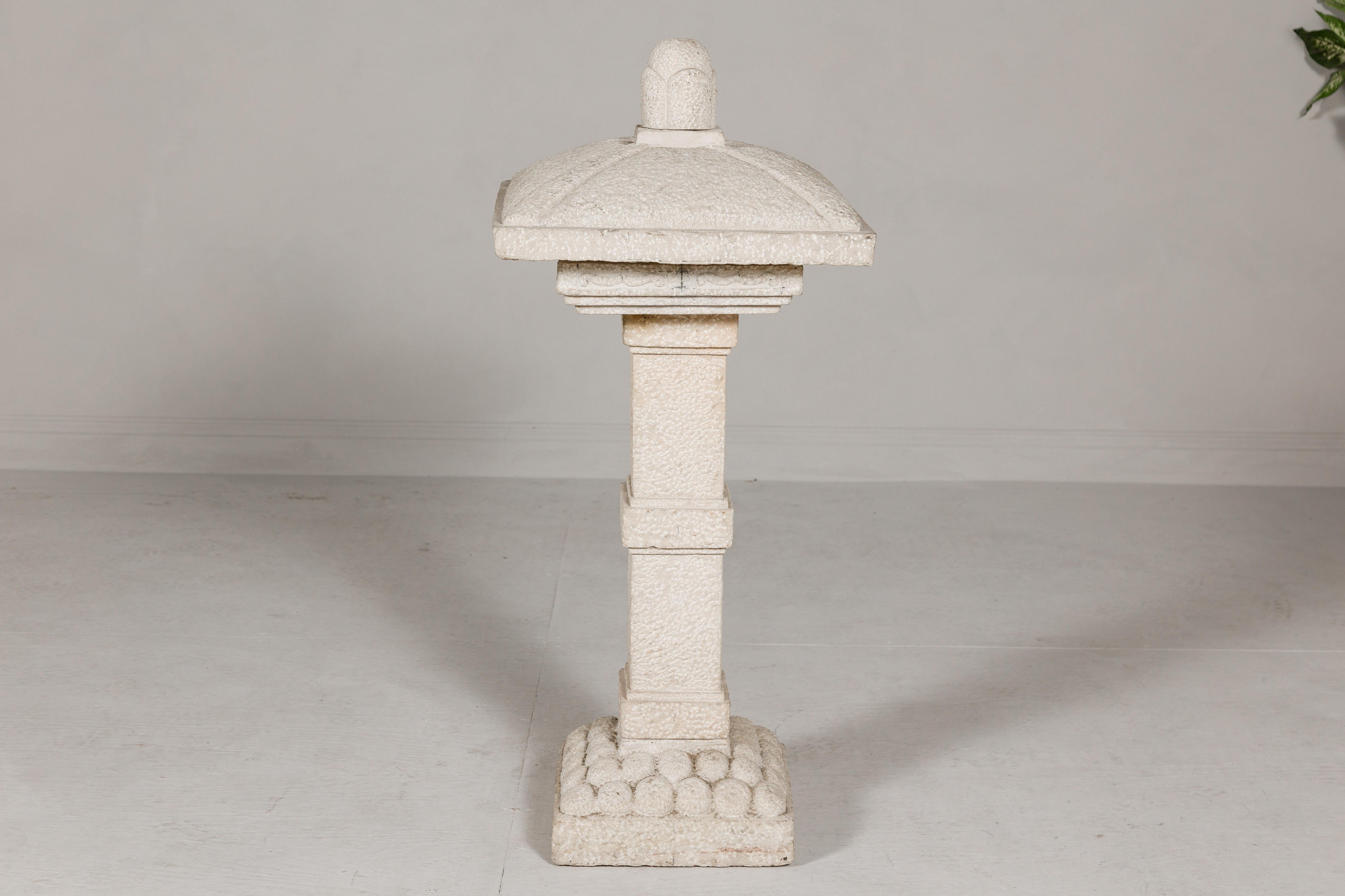A vintage Japanese carved stone pagoda made of five pieces. This vintage Japanese carved stone pagoda is a striking masterpiece that exudes timeless elegance. Crafted meticulously in five separate pieces, it showcases exquisite artistry and