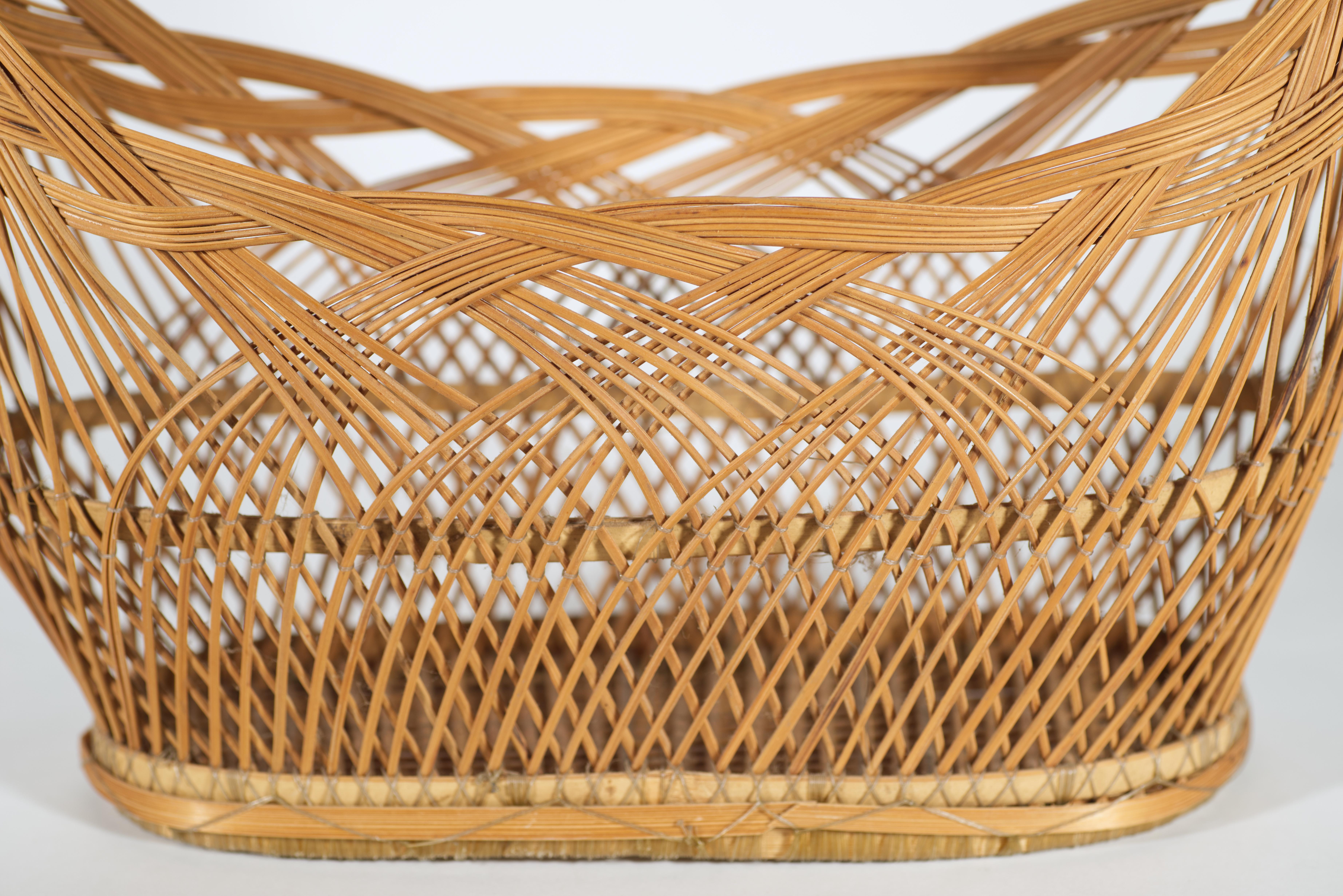  Le panier Ikebana vintage en bambou présente une forme allongée et aplatie avec une poignée arrondie proéminente. Le panier est tressé avec de fines bandes rondes de bambou fixées par des fibres transparentes, ce qui confère stabilité et durabilité
