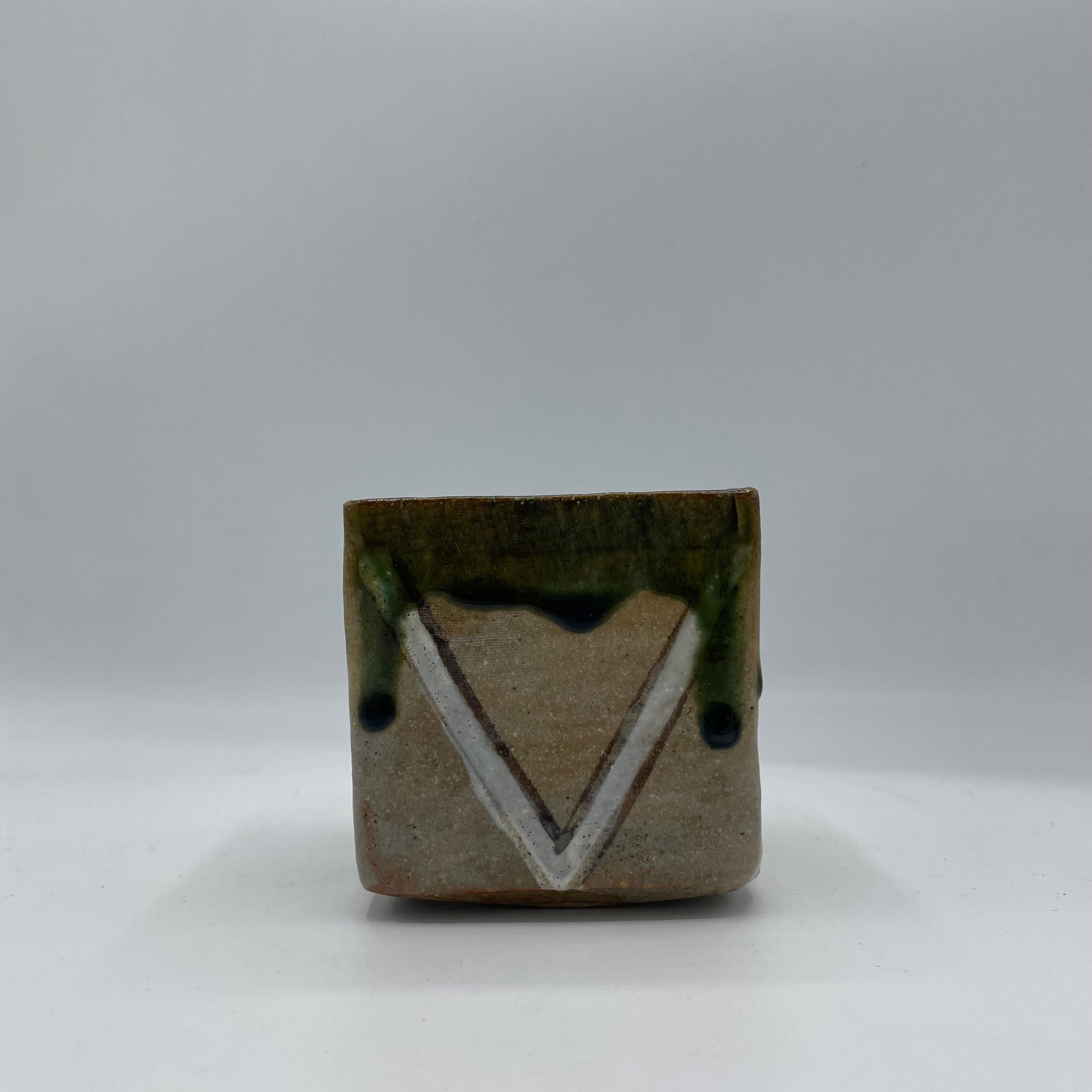 Il s'agit d'un vase à fleurs fabriqué au Japon dans les années 1980. 
Il s'agit d'un produit de type Oribe avec de la porcelaine.
Le fond porte la signature de Shunhou. 

Shunpō est un artiste céramiste qualifié ou un studio de poterie connu pour