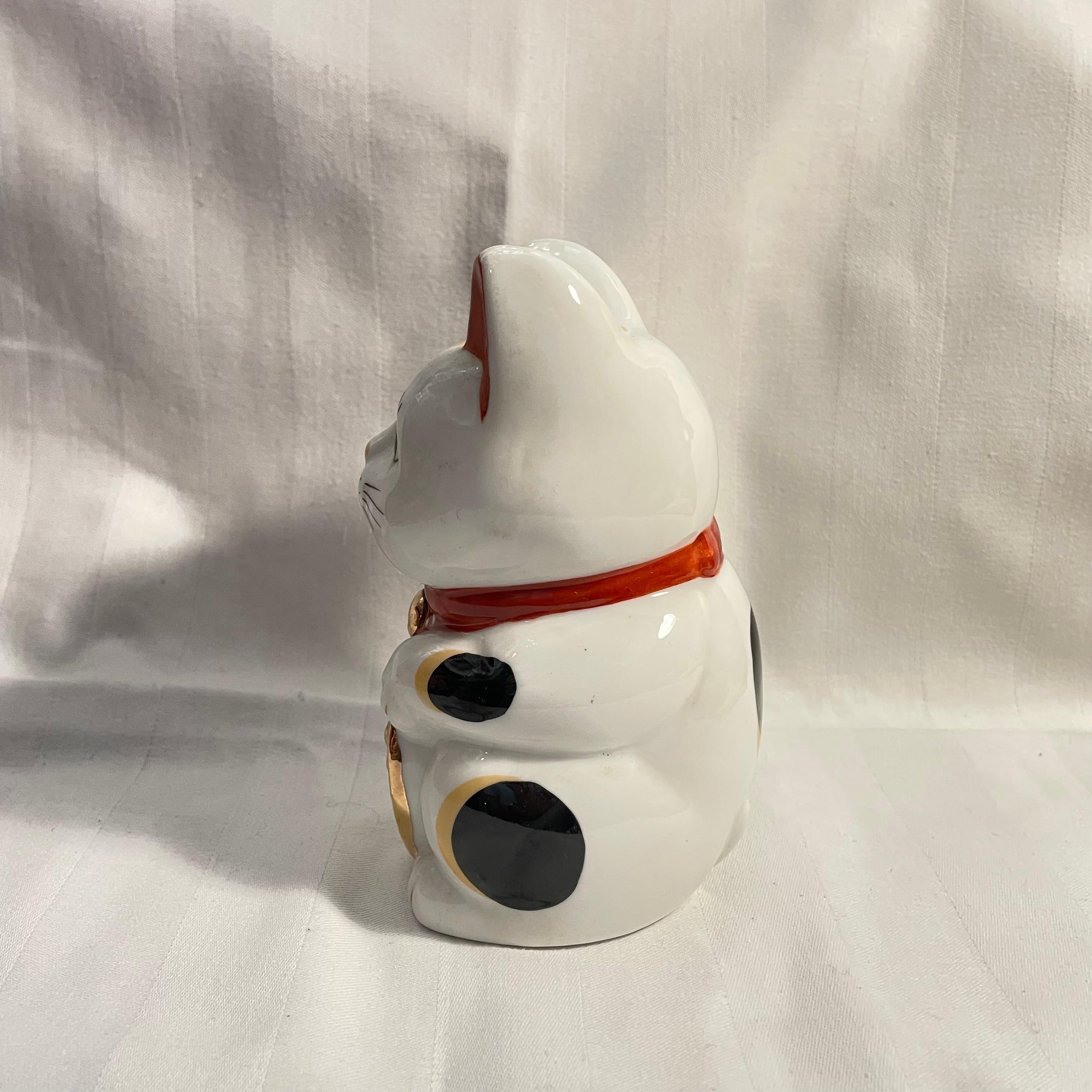 Dies ist ein Manekineko-Katzenobjekt. Sie ist aus Porzellan und wurde in den 1980er Jahren in der Showa-Ära hergestellt. 

Abmessungen. 
8 x 8.5 x H13 cm 

Das Maneki-Neko ist eine japanische Figur, von der man glaubt, dass sie dem Besitzer Glück