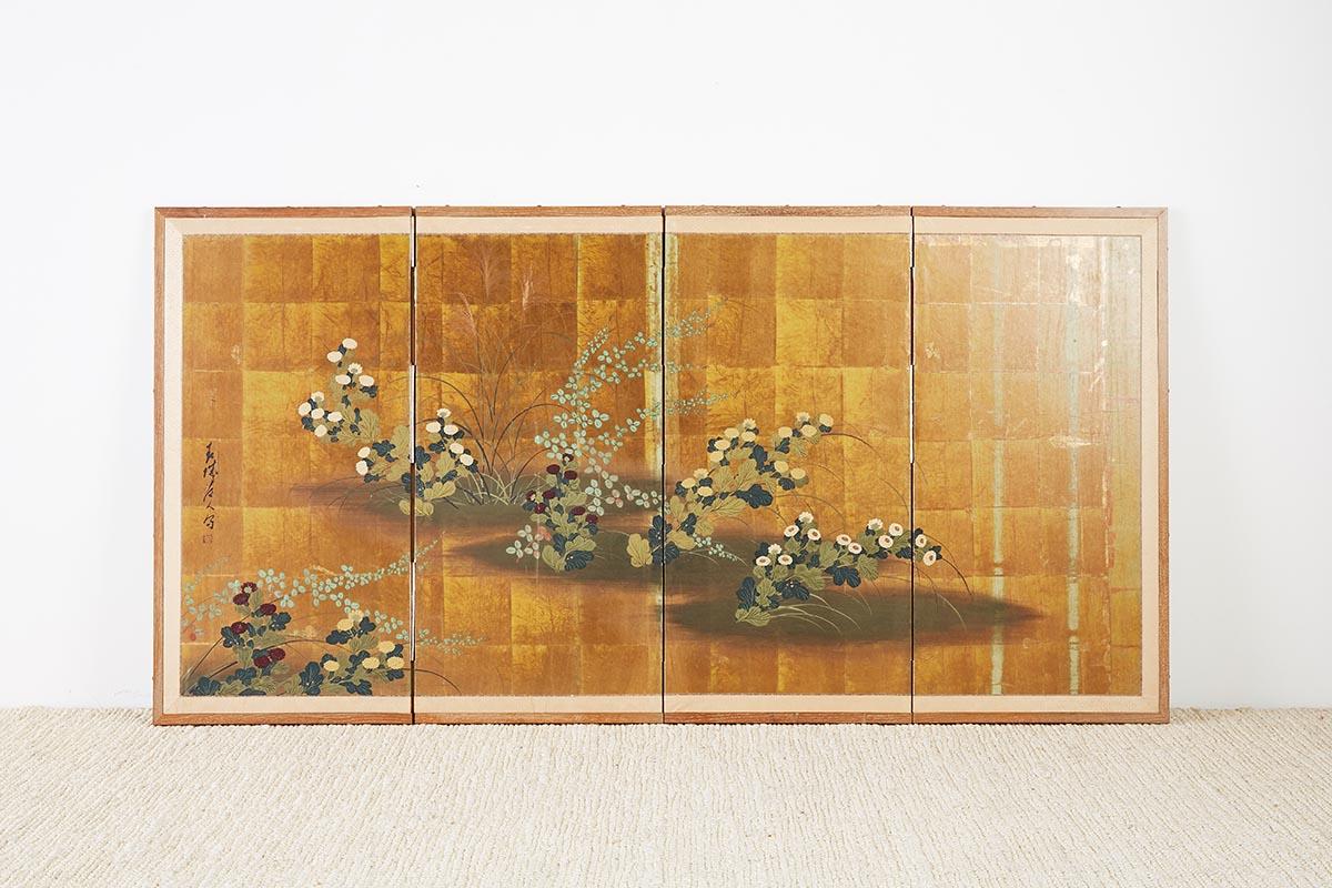 Vintage Japanese four panel byobu screen featuring painted flowers over a gold leaf background. Colorful verte foliage over squares of gold leaf with a dark patina. Signed on the left and set in a cerused wood frame with a brocade silk border. 