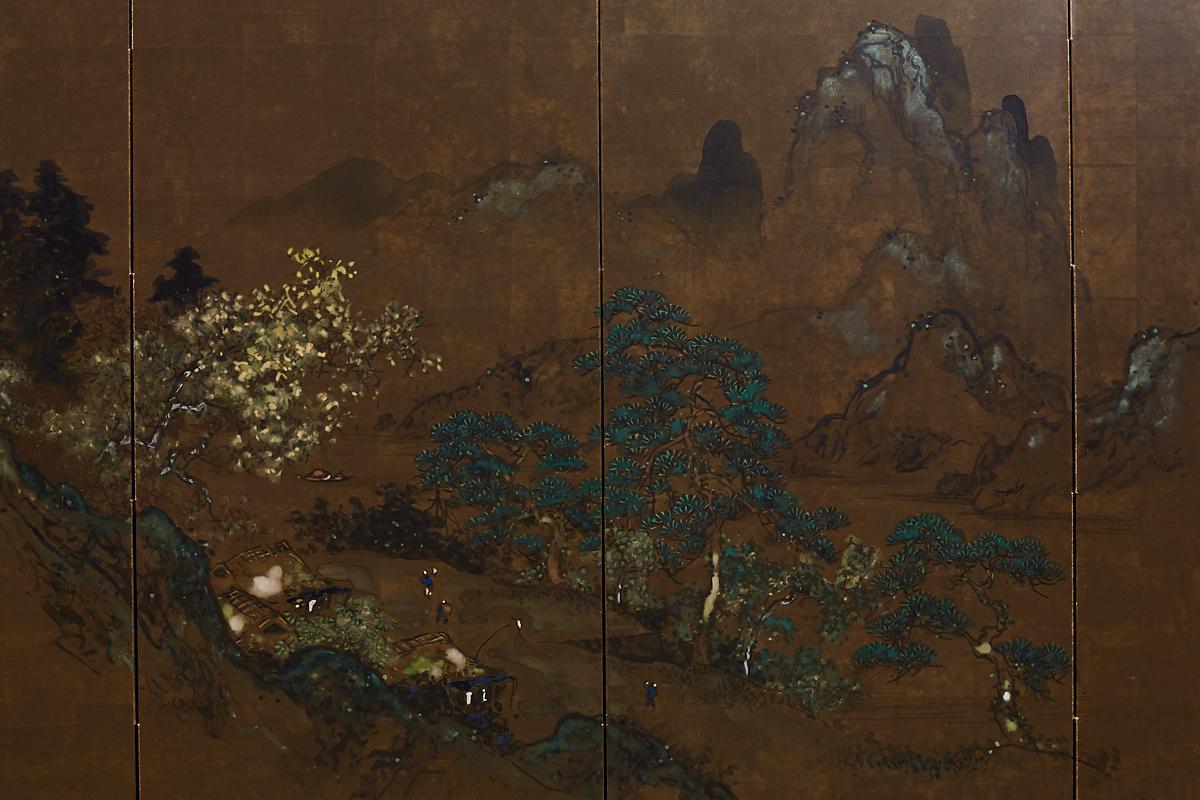 Hand-painted Japanese four-panel landscape Byobu screen. Features a mountain scene with pine trees and a village depicted in watercolor over gilt squares. Radiant colors stand out against the dark background in an almost iridescent way. Set in an