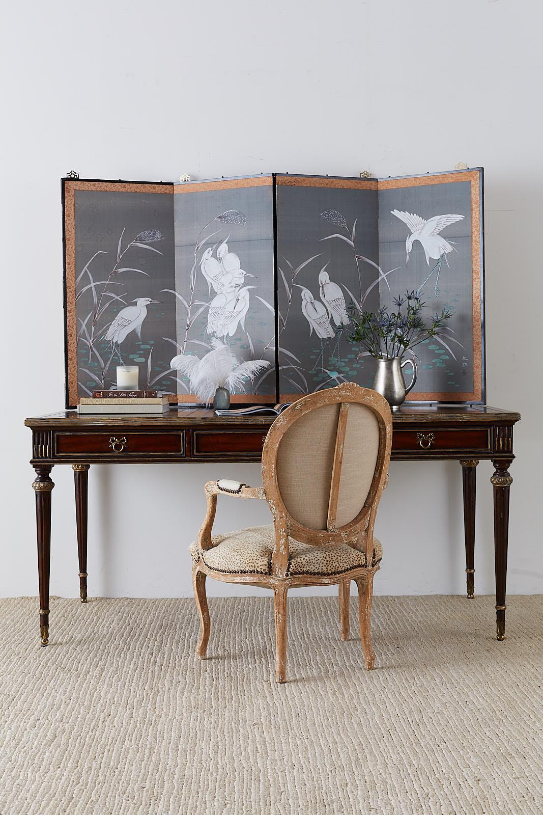 Spectacular Japanese four-panel screen depicting a group of white Japanese herons in a pond with reeds. Ink and colored pigments painted on an unusual silver silk ground. Signed on right by artist Tokin with a seal and set in a very heavy lacquered