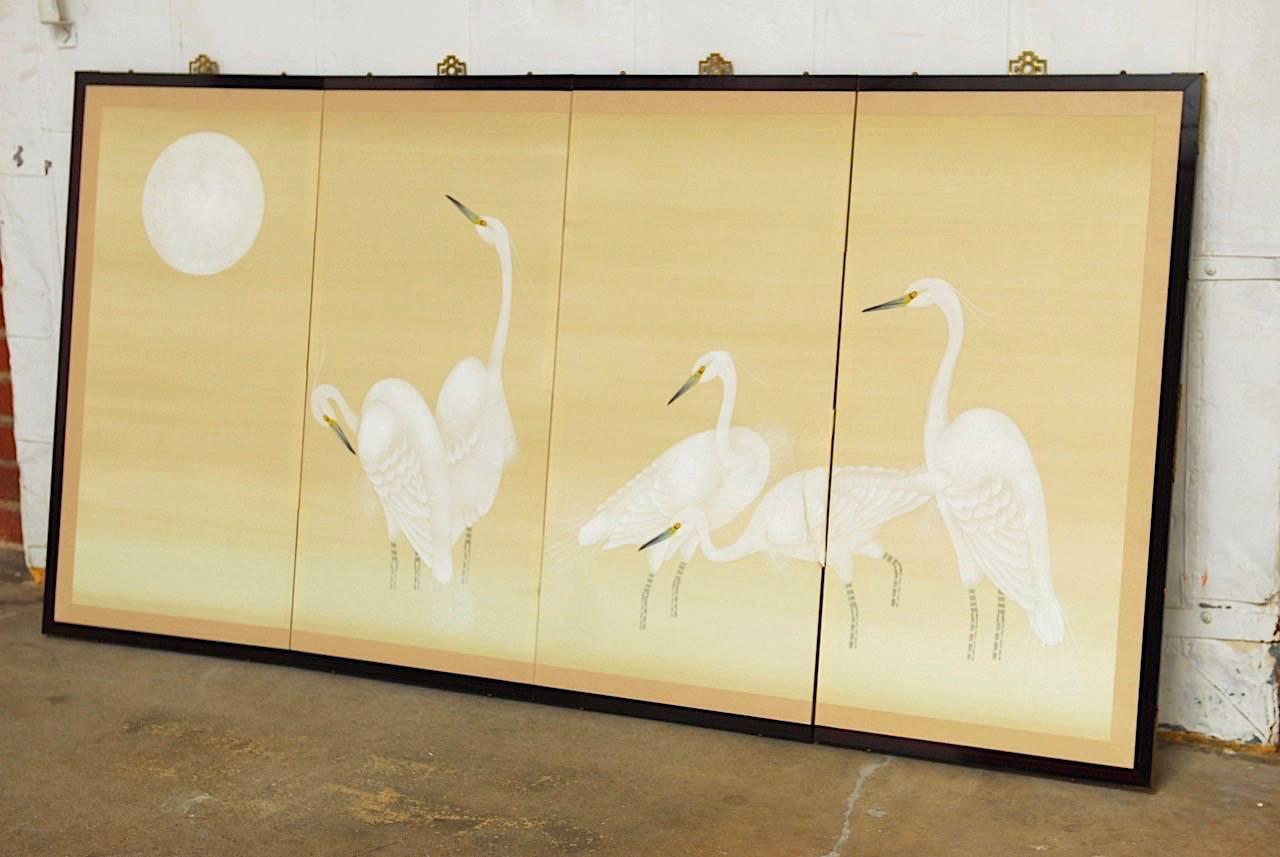 Extraordinary Japanese four-panel Byobu screen depicting fine white cranes under a full white moon. Painted on paper with a silk border and set in a solid rosewood frame with brass trim and hangers.
