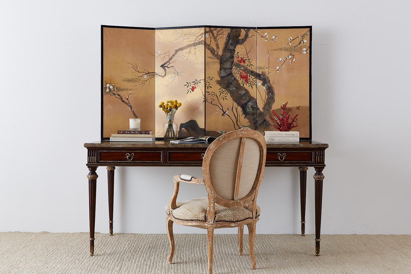 Colorful Japanese four-panel screen depicting a prunus tree with a songbird perched in a red fruiting Nandina or sacred bamboo. Made in the Nihonga school style. Ink and color pigments on gold colored paper. Signed by artist Shunsho with a seal and