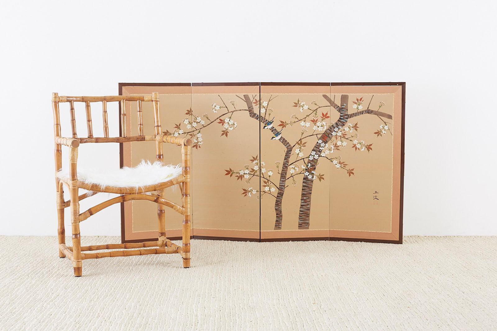 Colorful Japanese four-panel screen depicting a blossoming cherry or sakura tree in spring. Painted with ink and color on a gold silk ground with beautiful little birds. Made in the Nihonga school style and signed by artist Kyuha with a seal on the