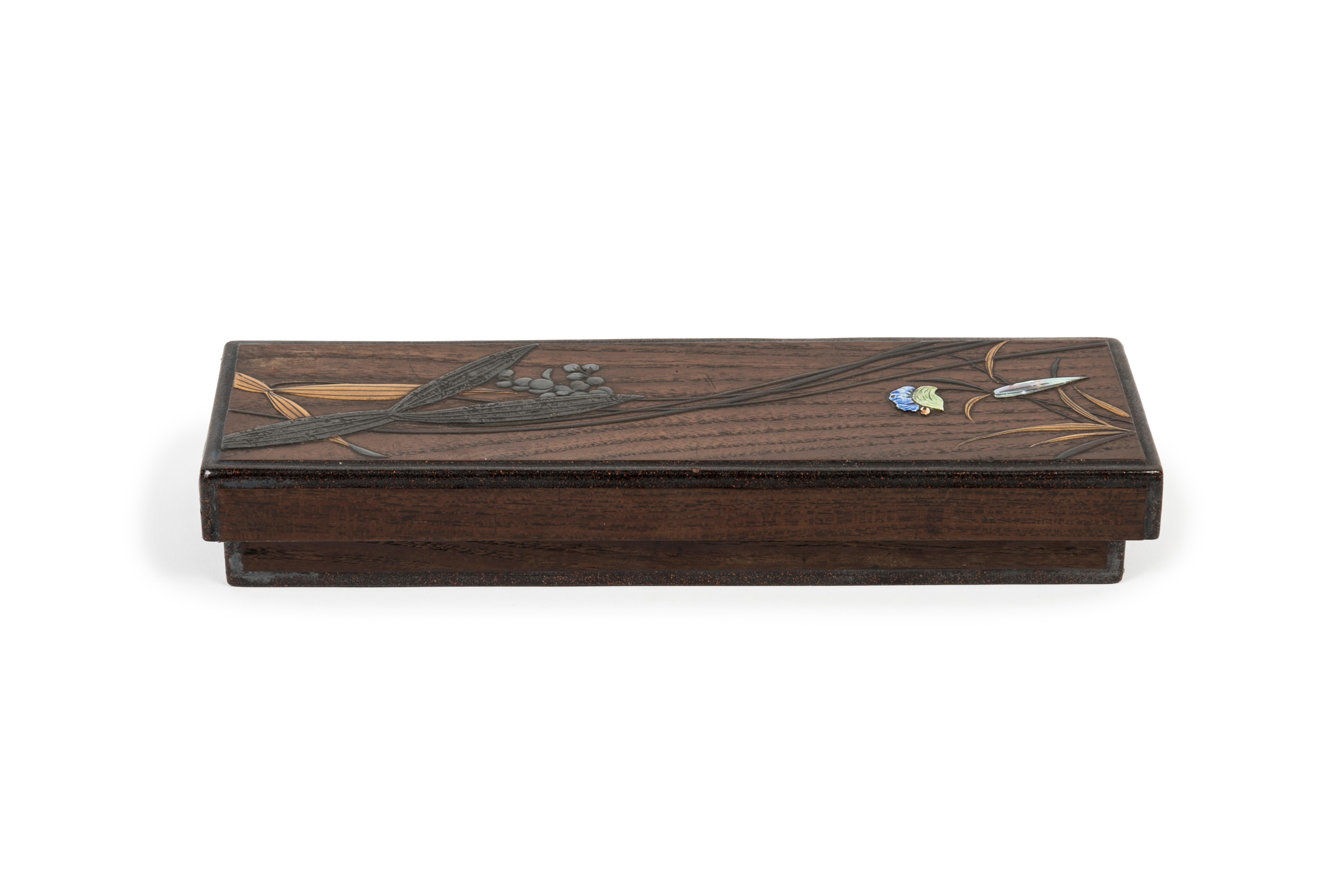 La scatola dei pennelli (fudebako) è realizzata in legno e lacca. Sul coperchio, decorazione in lacca raffigurante il sagittario, un fiore intarsiato in ceramica e una foglia intarsiata (raden).
Interno e base della scatola in lacca nashi-ji.