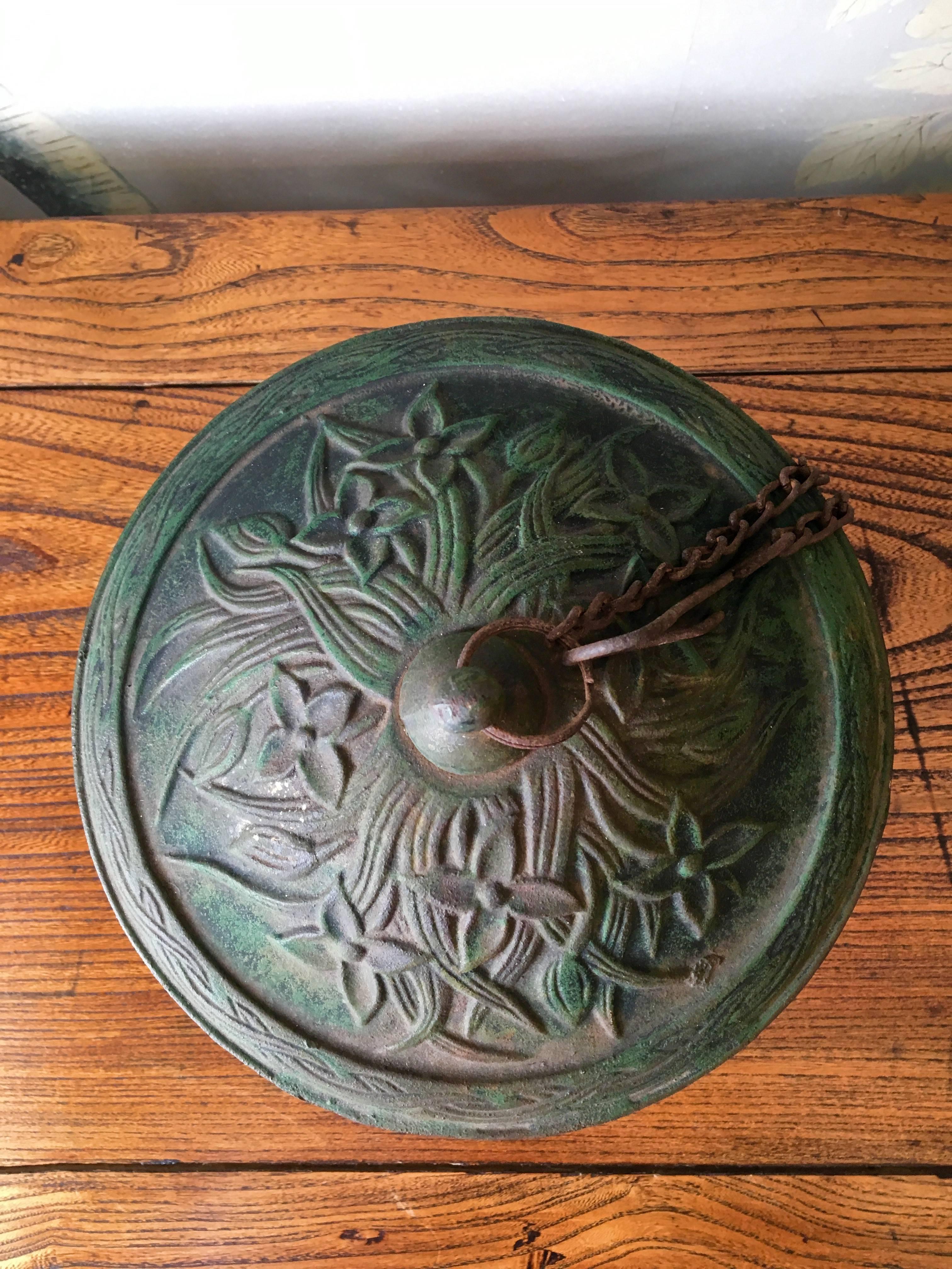 A vintage cast iron Japanese garden lantern with chain and hook for hanging.