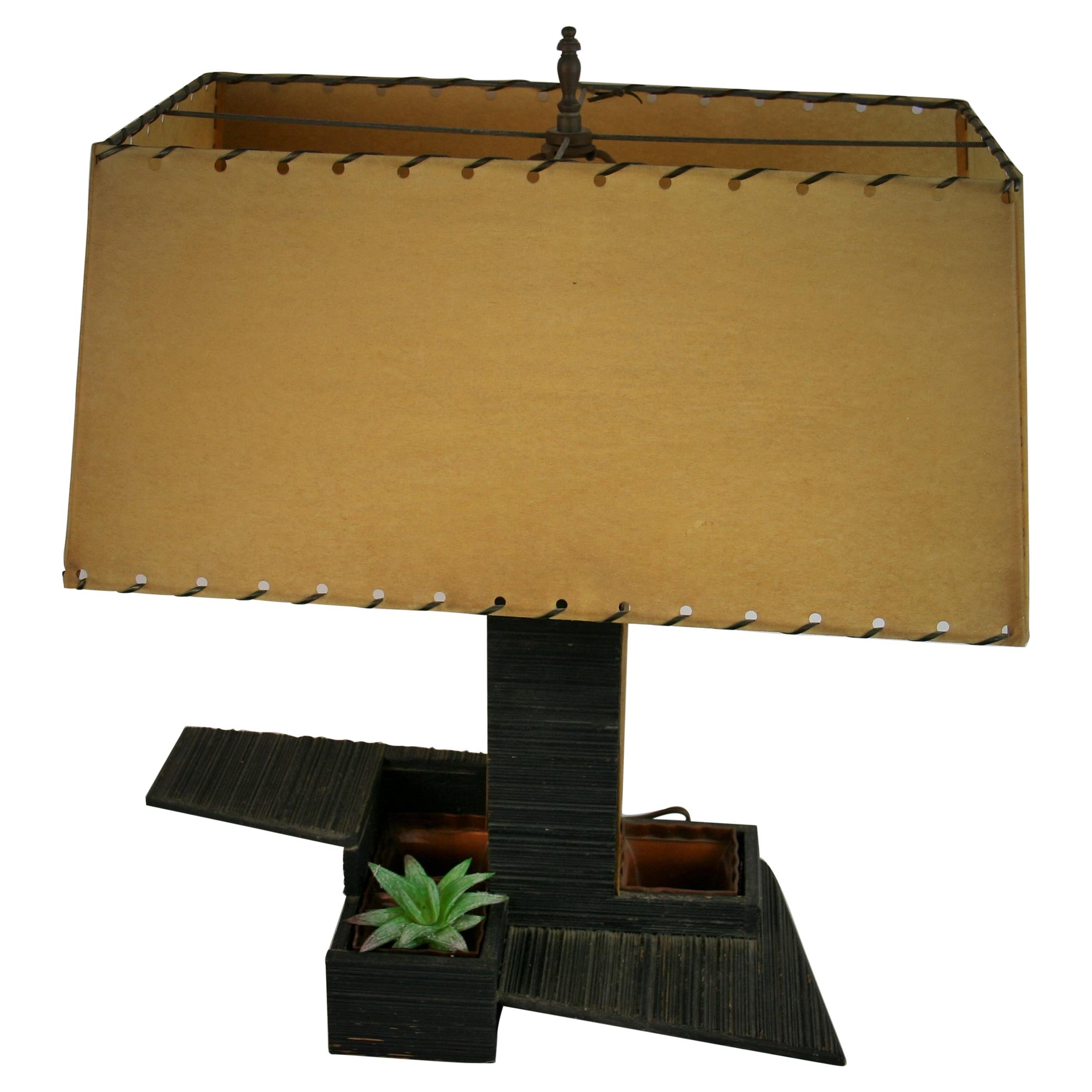 8-278 Japanese garden planter lamp made out of striated wood.
Lamp has on internal light in center tower with velum sides. Original braded lampshade
Original wiring in good condition. Three way switch to turn on main light and center light,
3