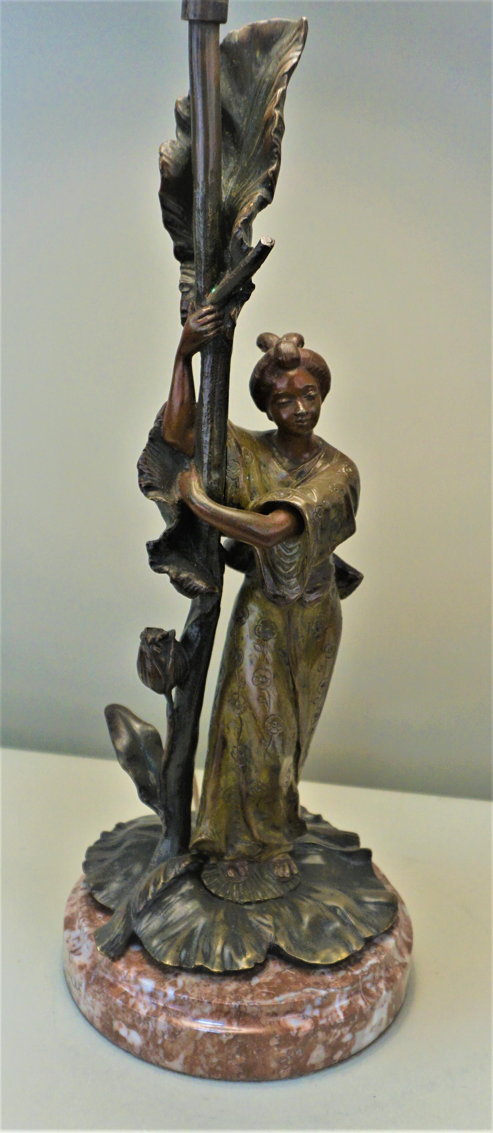 An Art Nouveau bronze table lamp with Japanese Geisha in Kimono dress, signed A Leblanc
Was purchased in France and rewired and fitted with silk lampshade.
