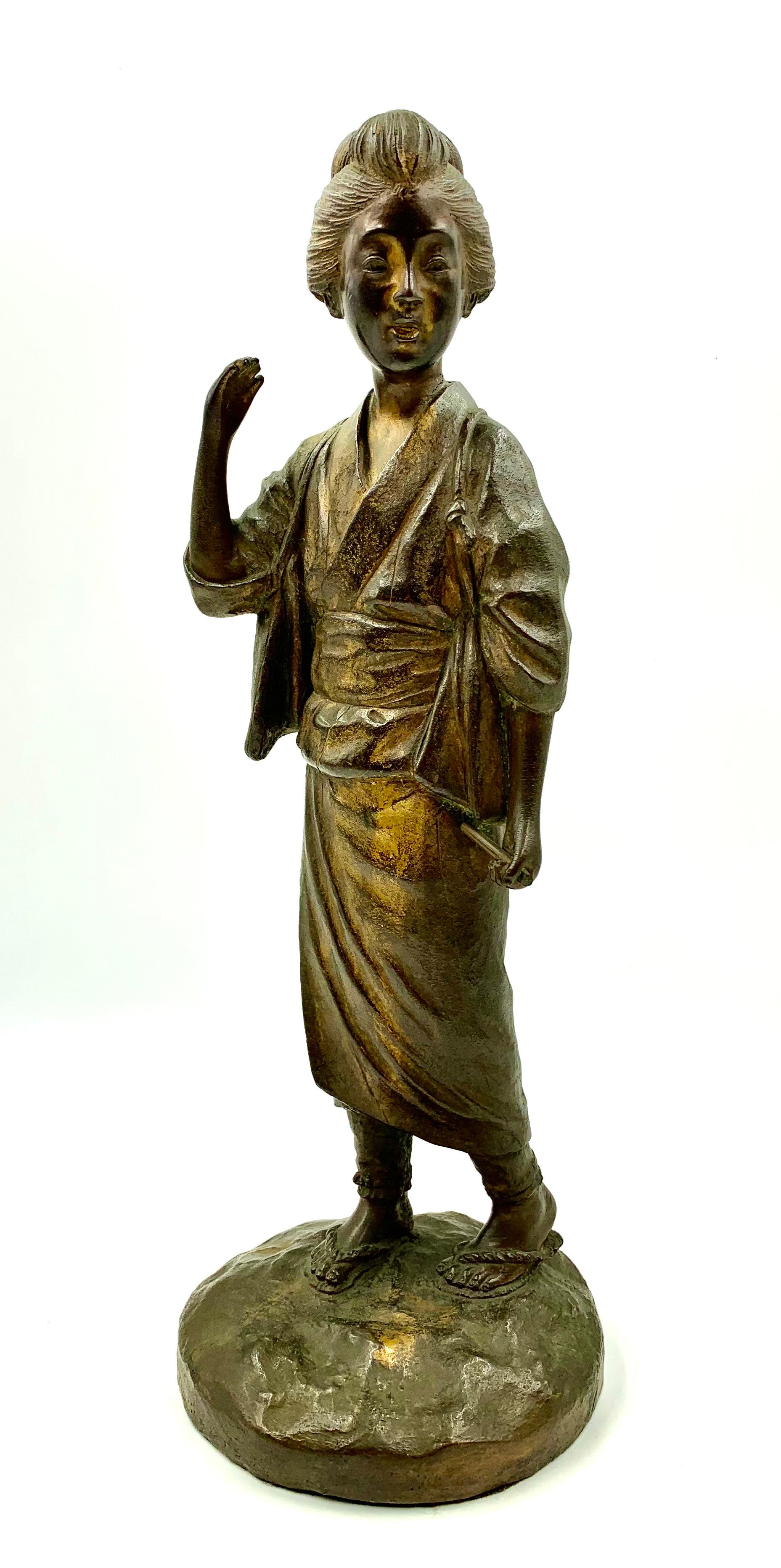 Japanese Meiji period patinated bronze sculpture of a geisha waiving her hand in greeting signed Genryusai Seiya
19th Century
The attractive young geisha is dressed in traditional Japanese kimono and beautifully woven sandals. Her hair is done up in