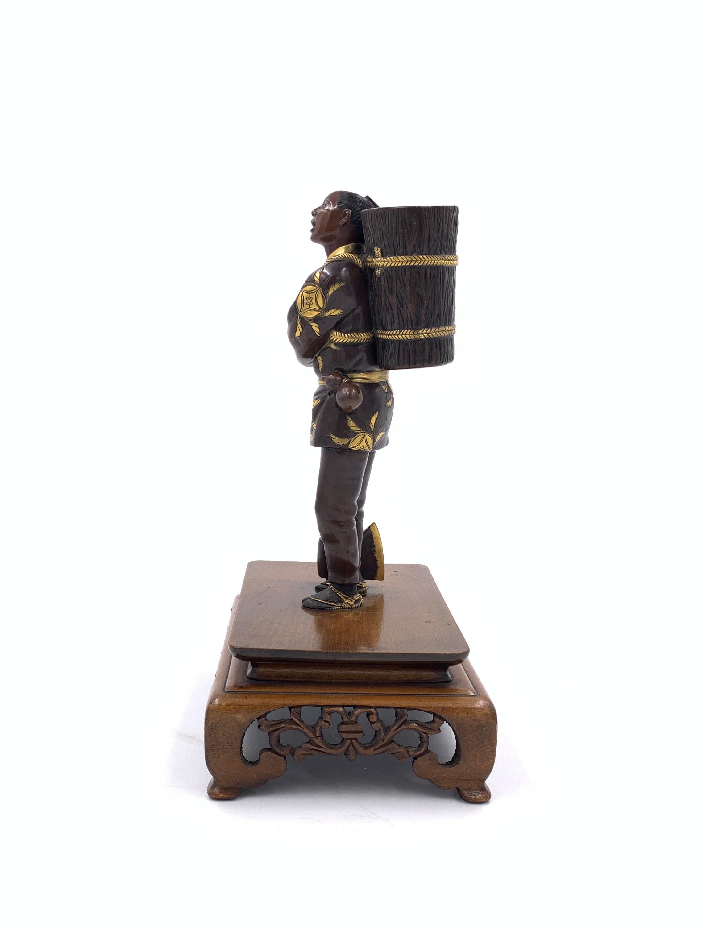 A fine signed Japanese gilt bronze figure, leans on his axe while carrying the basket on his back, signed at the base of the basket.
 