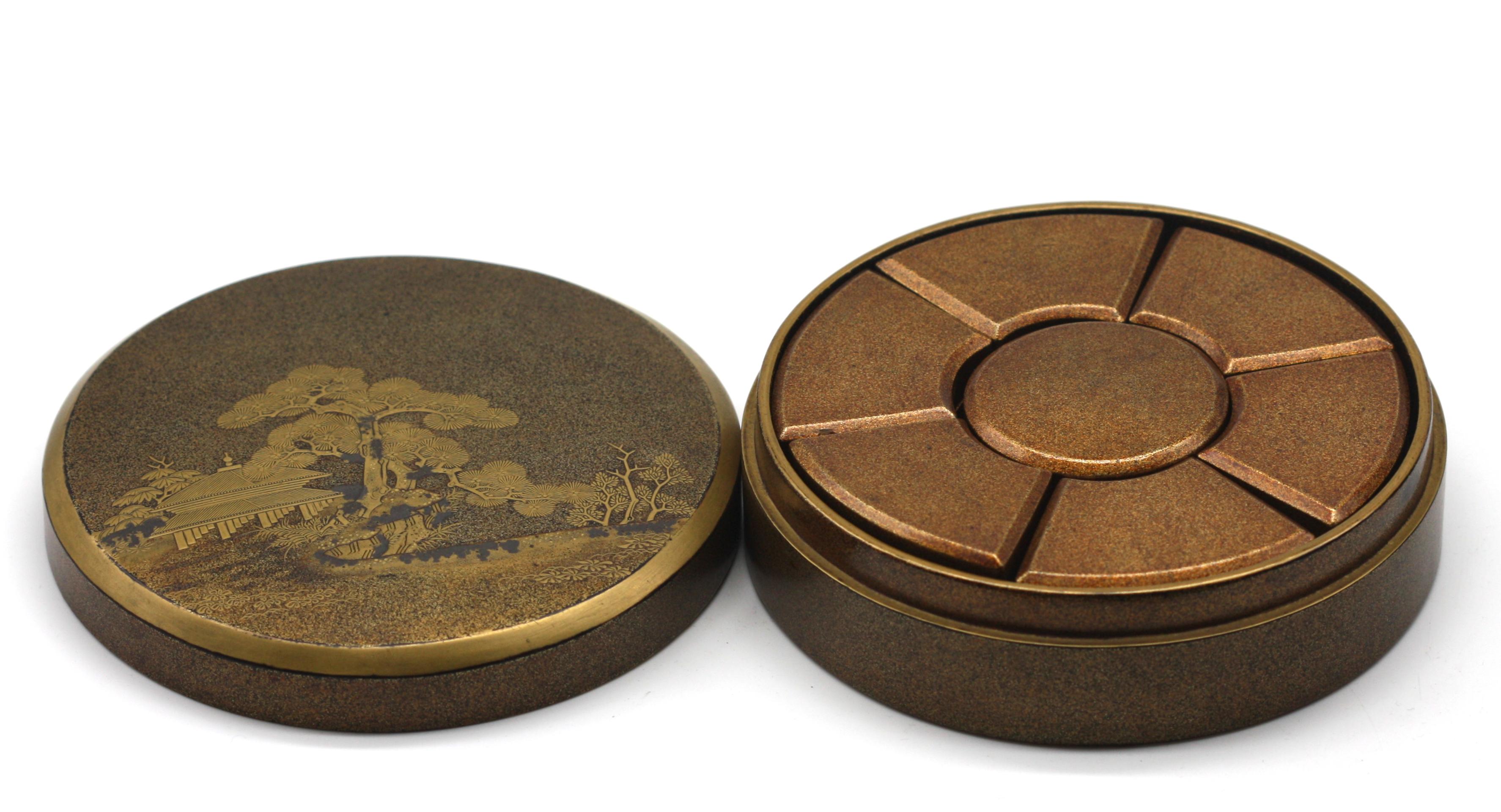 
Japanese Gilt Lacquer Covered Sweet Meat Box
Meiji Period. The circular box decorated with a raised evergreen tree before a pavilion, opening to multiple removeable lidded compartments.
Height 1.75 in., Diameter 5.75 in.