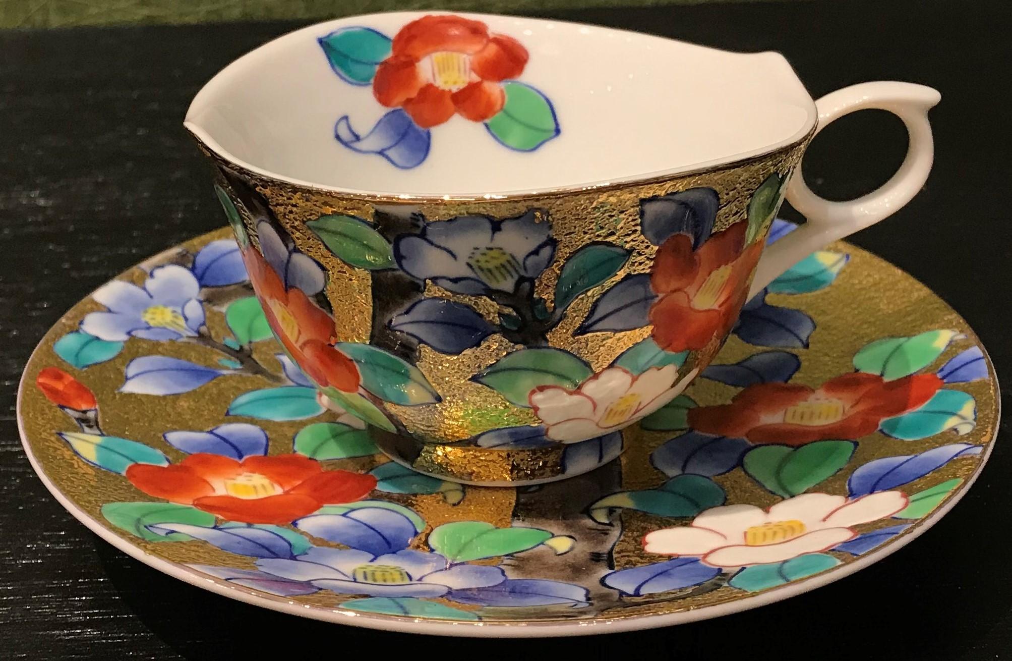 Extraordinary contemporary gilded fine porcelain cup and saucer, intricately hand painted in vivid red, white, blue and green on an attractive gilded body, featuring stunning camellias in full bloom.
This cup and saucer is from a signature series by