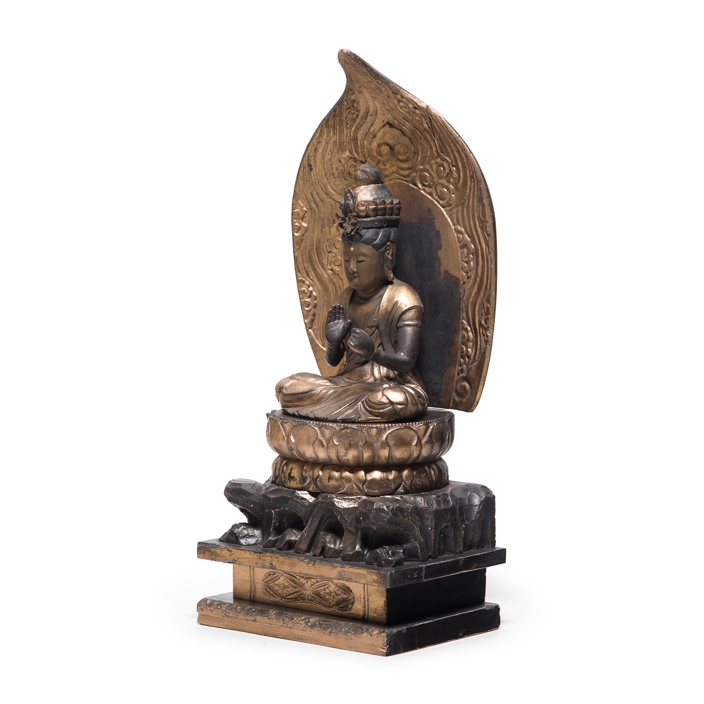 Die kunstvoll geschnitzte und mit vergoldetem schwarzen Lack überzogene sitzende Figur stellt den Bodhisattva Guanyin dar, der im japanischen Buddhismus als Kannon bekannt ist. Beschrieben als der 