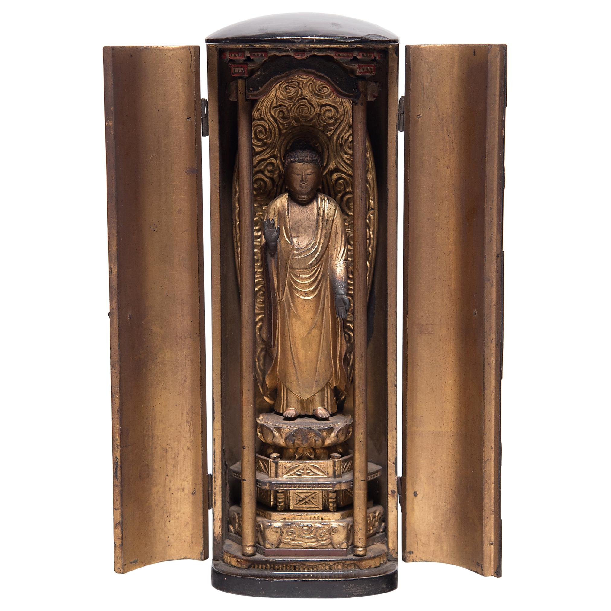 The simple exterior of even black lacquer that encases this 19th century Japanese traveling shrine belies the splendor within. The hinged doors open to a gilt interior framing an intricately carved figure of the historical Buddha, known in Japanese