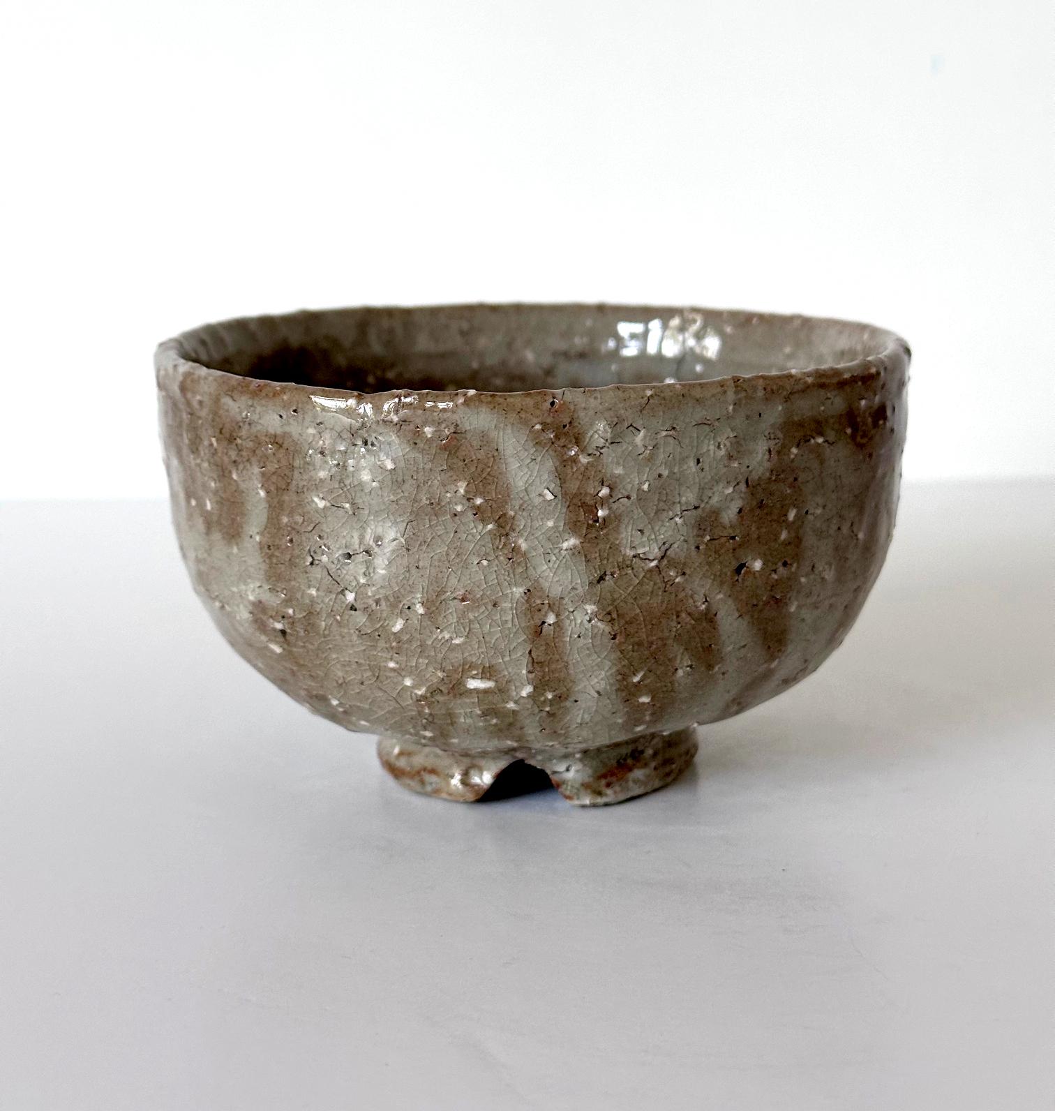 Bol à thé japonais en céramique émaillée (chawan) de style Gohon, probablement fabriqué au cours de la période Showa du 20e siècle. Soutenu par un anneau de pied court avec une encoche, le bol a été fabriqué à partir d'argile grossière avec une