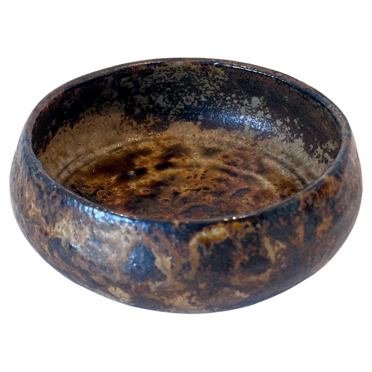 Cuenco redondo de gres con espectacular vidriado, fabricado por Kitaoji Rosanjin (1883-1959) hacia la primera mitad del siglo XX. El cuenco de poca altura, con una abertura ancha y un cuerpo abombado, se parece al cuenco de limosna de un monje y lo