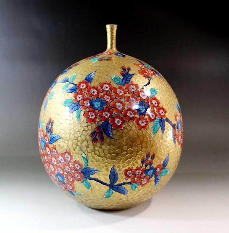 Exquisite Japanese contemporary porcelain vase on a stunning dimpled globular shape in gold and delicate long neck, adorned with hand painted clusters of cherry blossoms in iron red, set against a dimpled background in gold, a masterpiece by widely