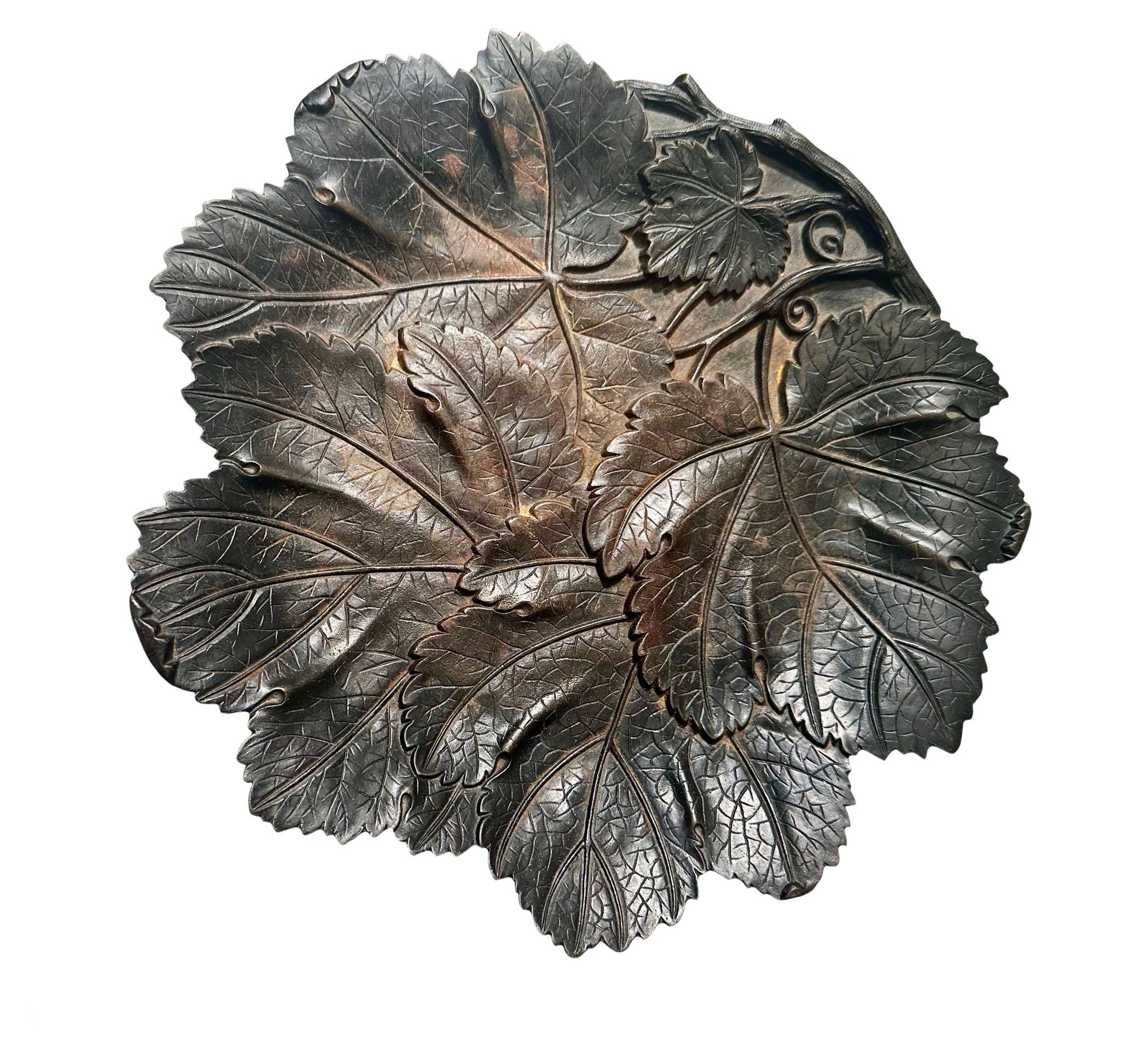 Una bandeja de uvas japonesa de hierro. Las hojas de parra representadas en esta bandeja están bellamente ejecutadas y el detalle es impecable. Tiene una pátina oscura con toques anaranjados. Se fabricó para exportarlo a Inglaterra o América.